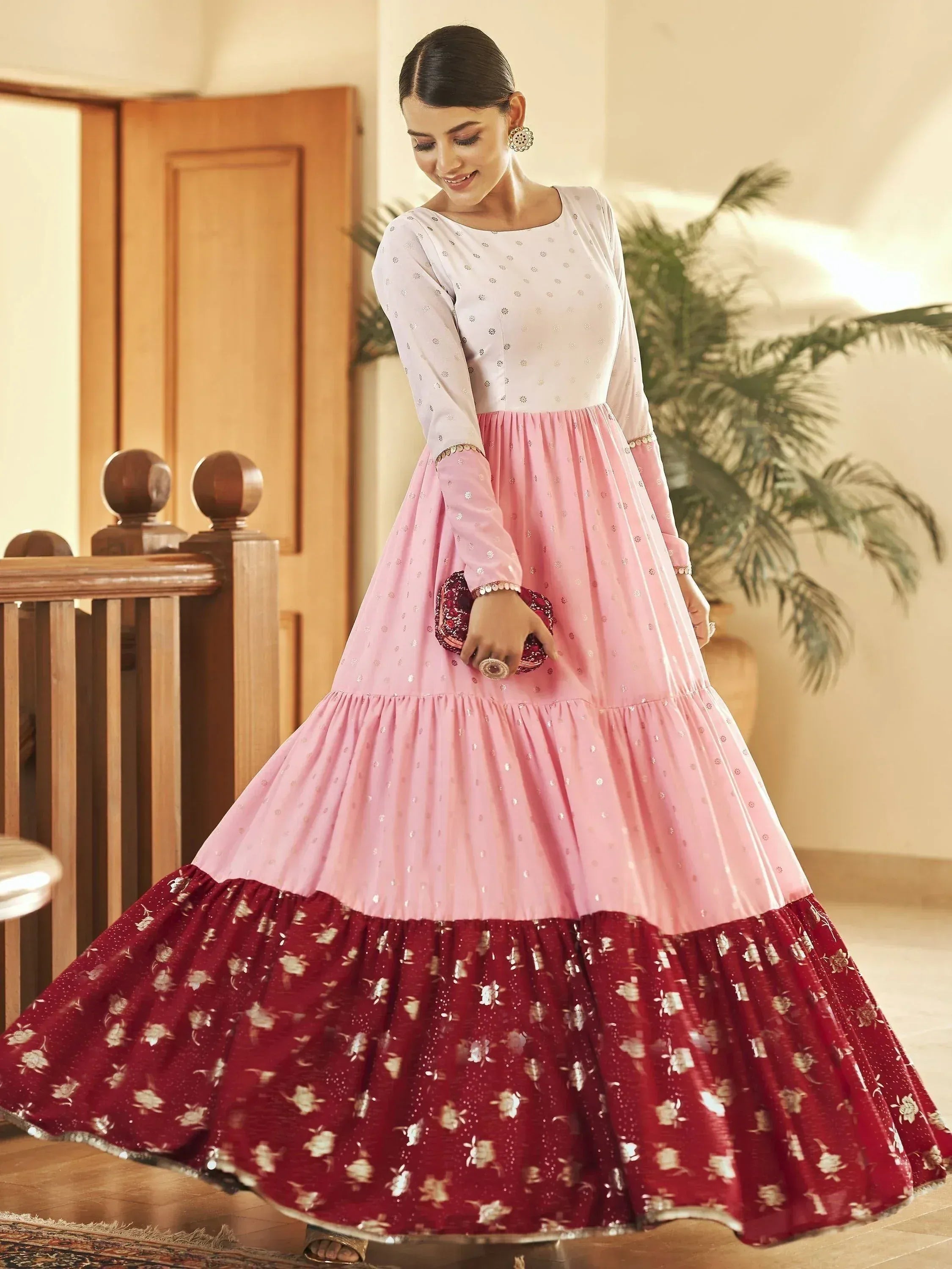 Elegant pink and maroon tiered ethnic gown with floral print, perfect for festive occasions.