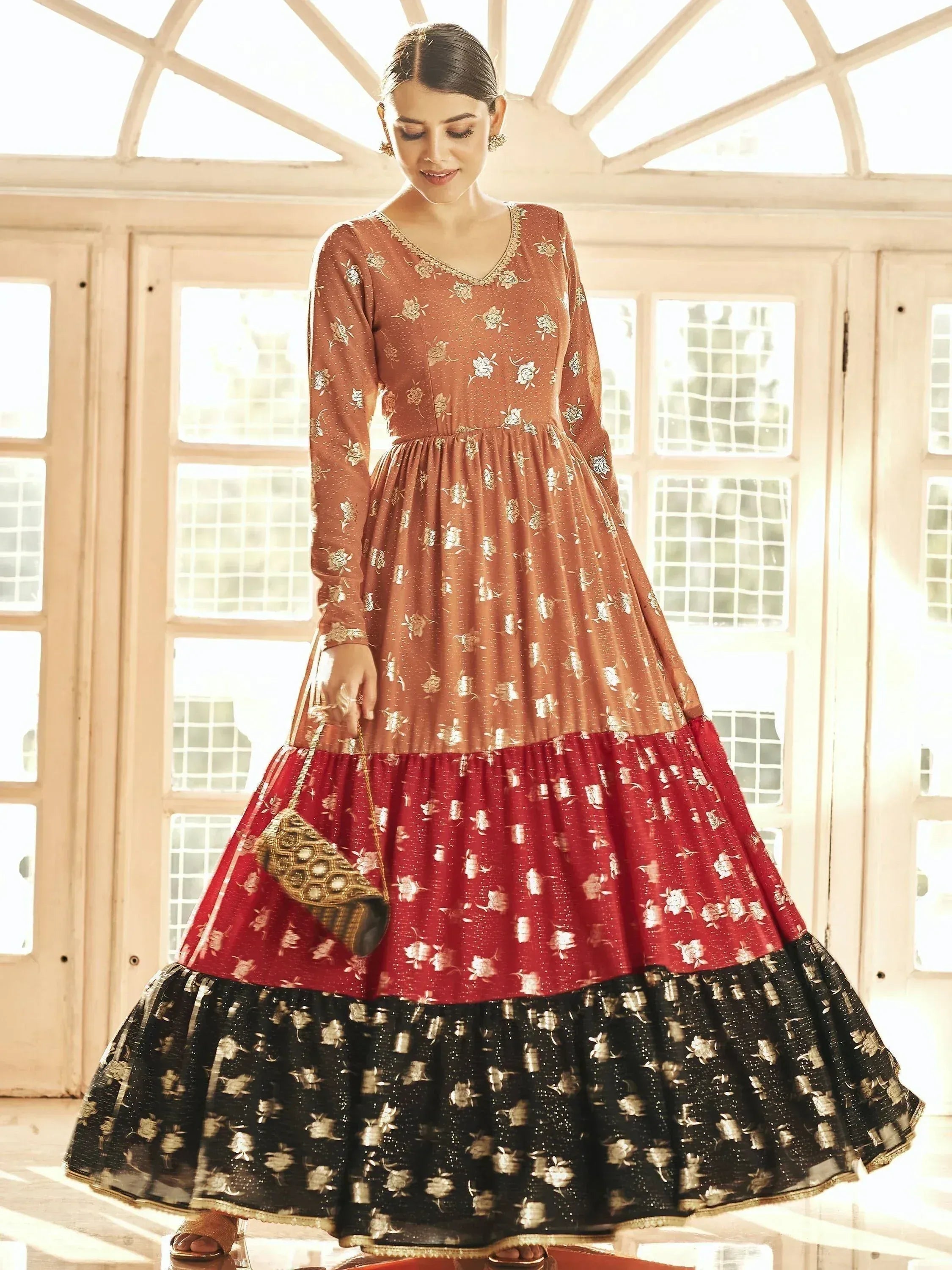 Elegant ethnic gown with floral print, tiered skirt in rust, red & black, perfect for Indian occasions.