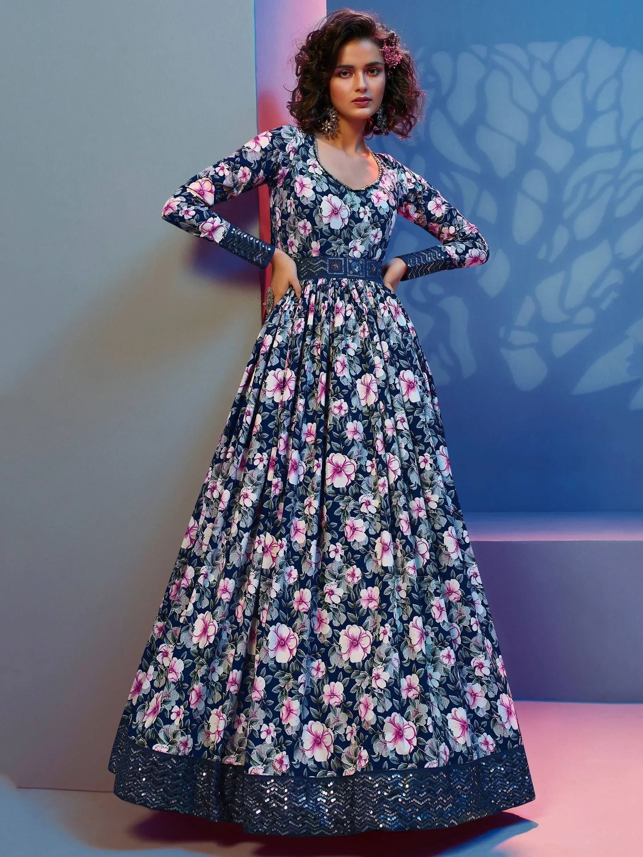 Woman wearing a navy blue floral full-length ethnic gown with long sleeves and flared skirt