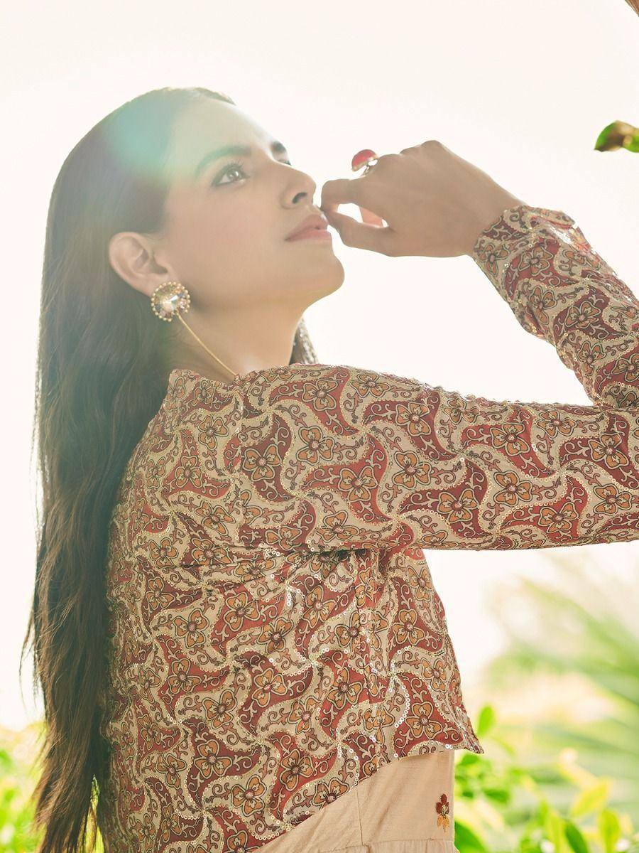 Woman in floral ethnic top with mirror work, wearing statement earrings, styled for Indian fashion