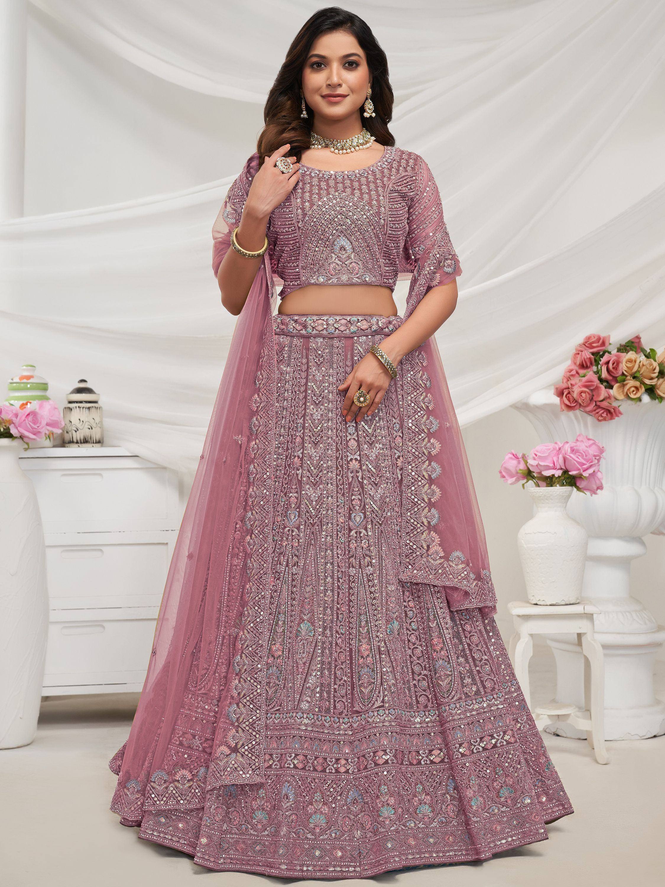 Elegant dusty pink designer lehenga choli with intricate embroidery and sequin work, perfect for weddings and festive occasions.