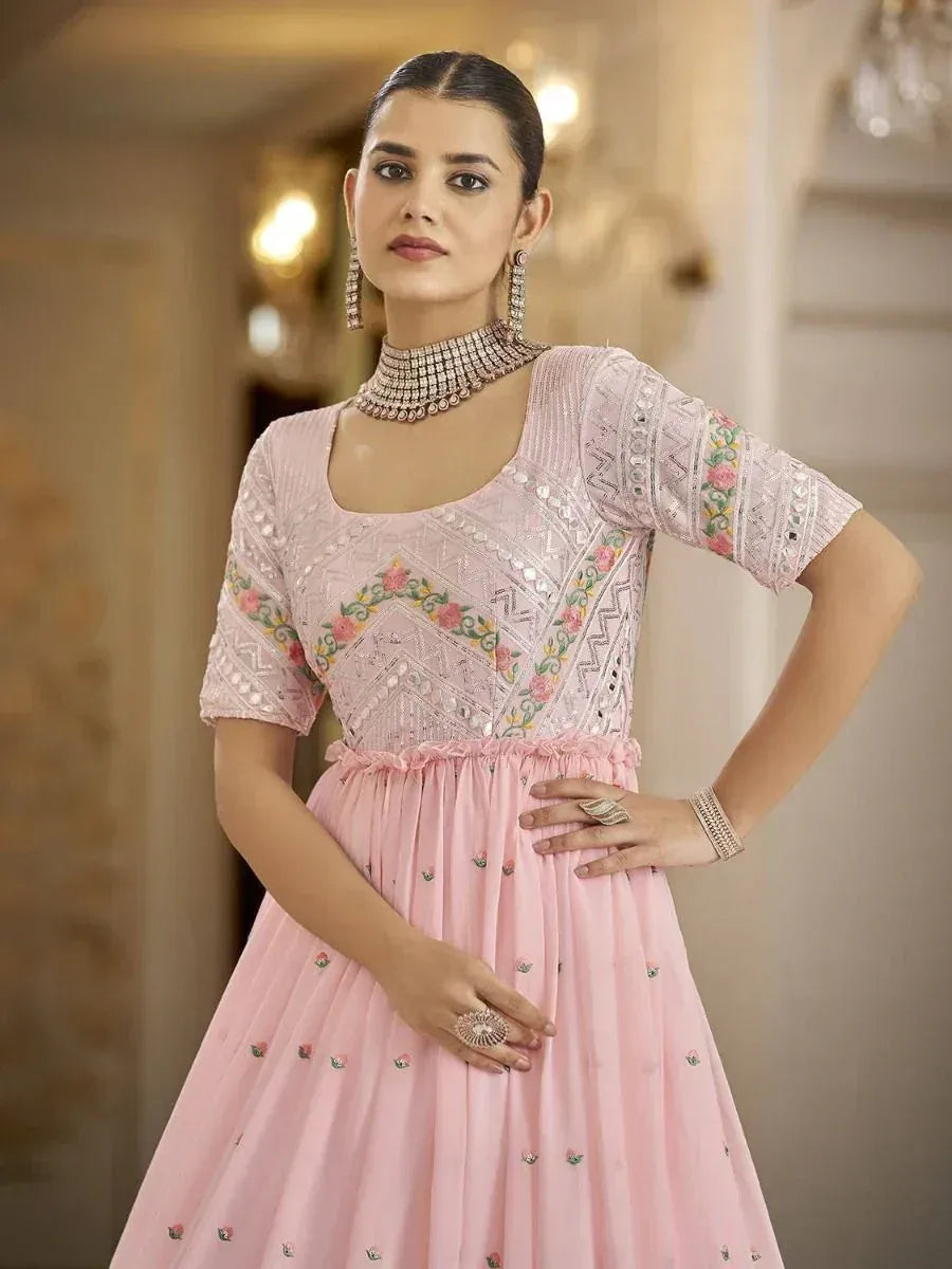 Pink embroidered ethnic gown with floral motifs and mirror work, styled with choker and earrings
