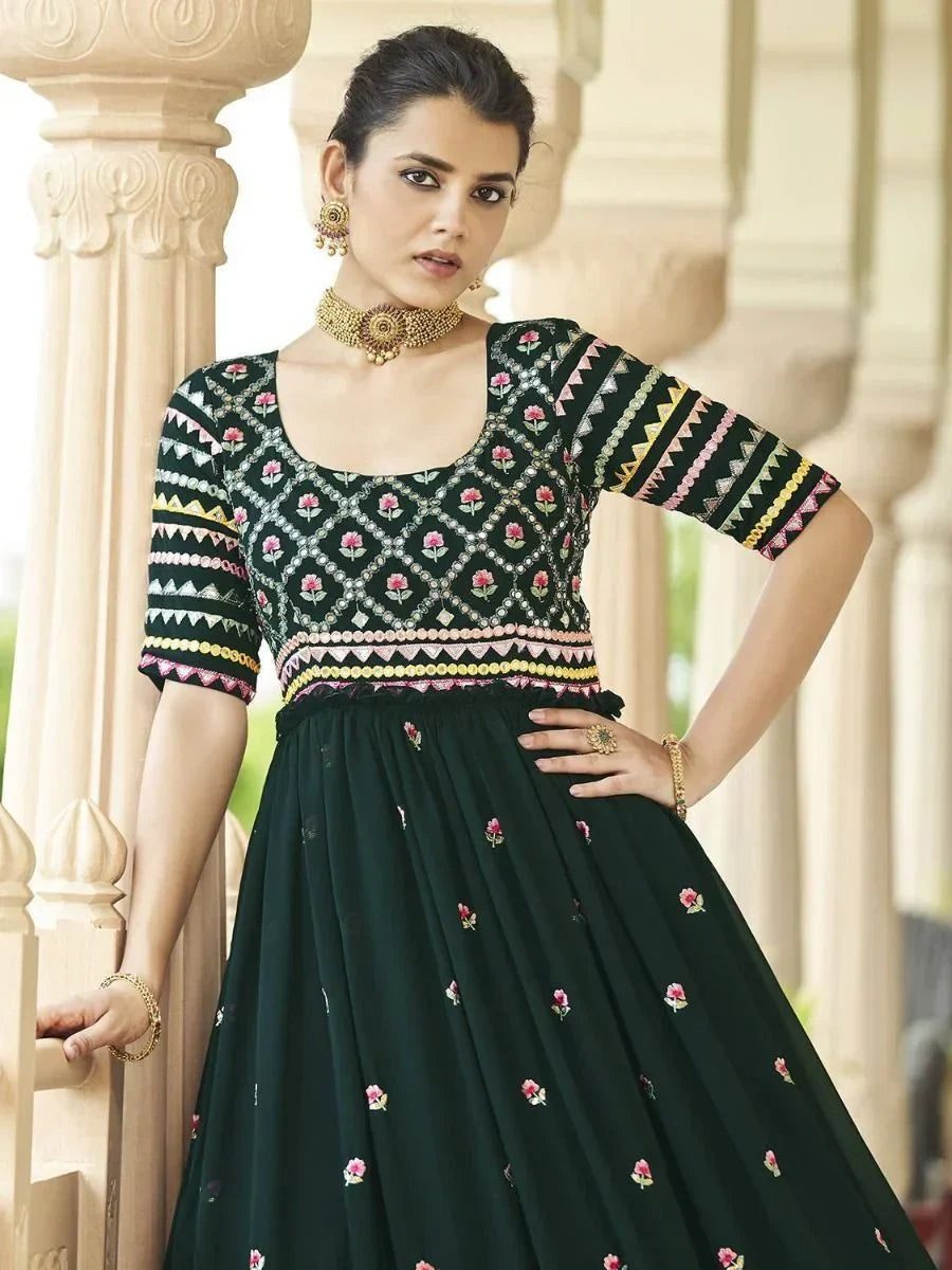 Woman in green embroidered lehenga choli with floral patterns and traditional jewelry