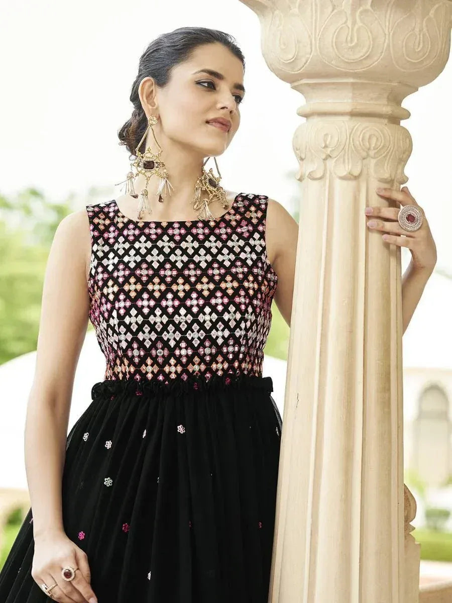 Black ethnic gown with pink and silver mirror work, paired with statement jewelry, perfect for Indian occasions.