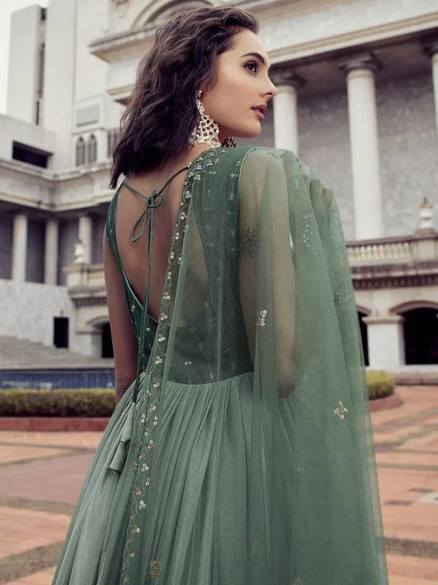 Elegant green ethnic gown with sheer cape, sequin embroidery, and back tie detail, perfect for Indian occasions.