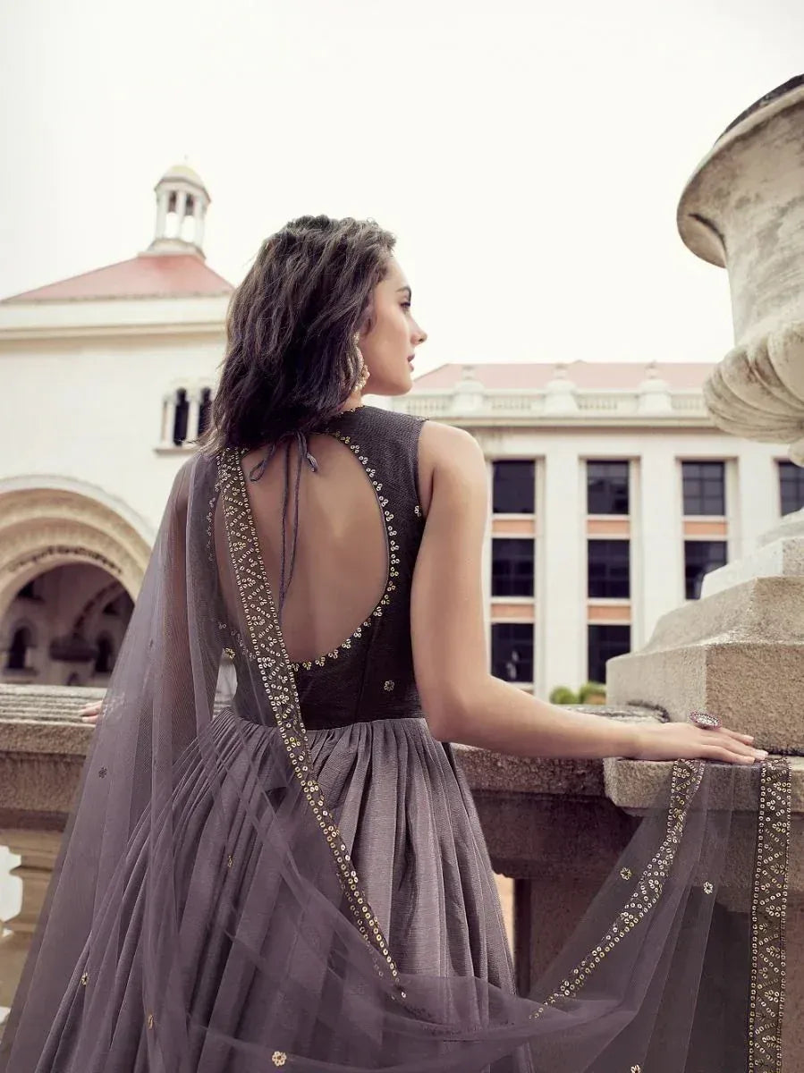 Elegant grey ethnic gown with open back and gold embroidery, perfect for Indian occasions