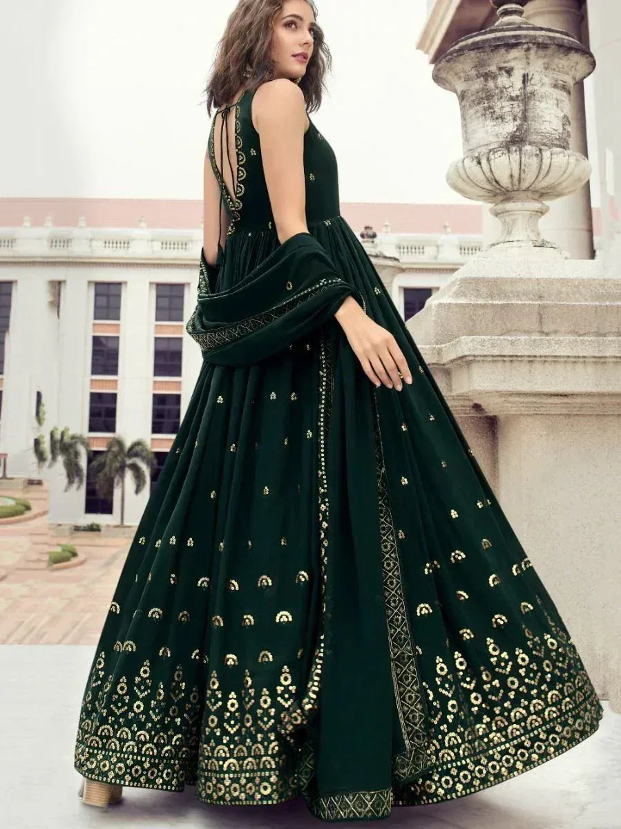 Woman wearing a designer dark green embroidered Indian ethnic gown with gold motifs