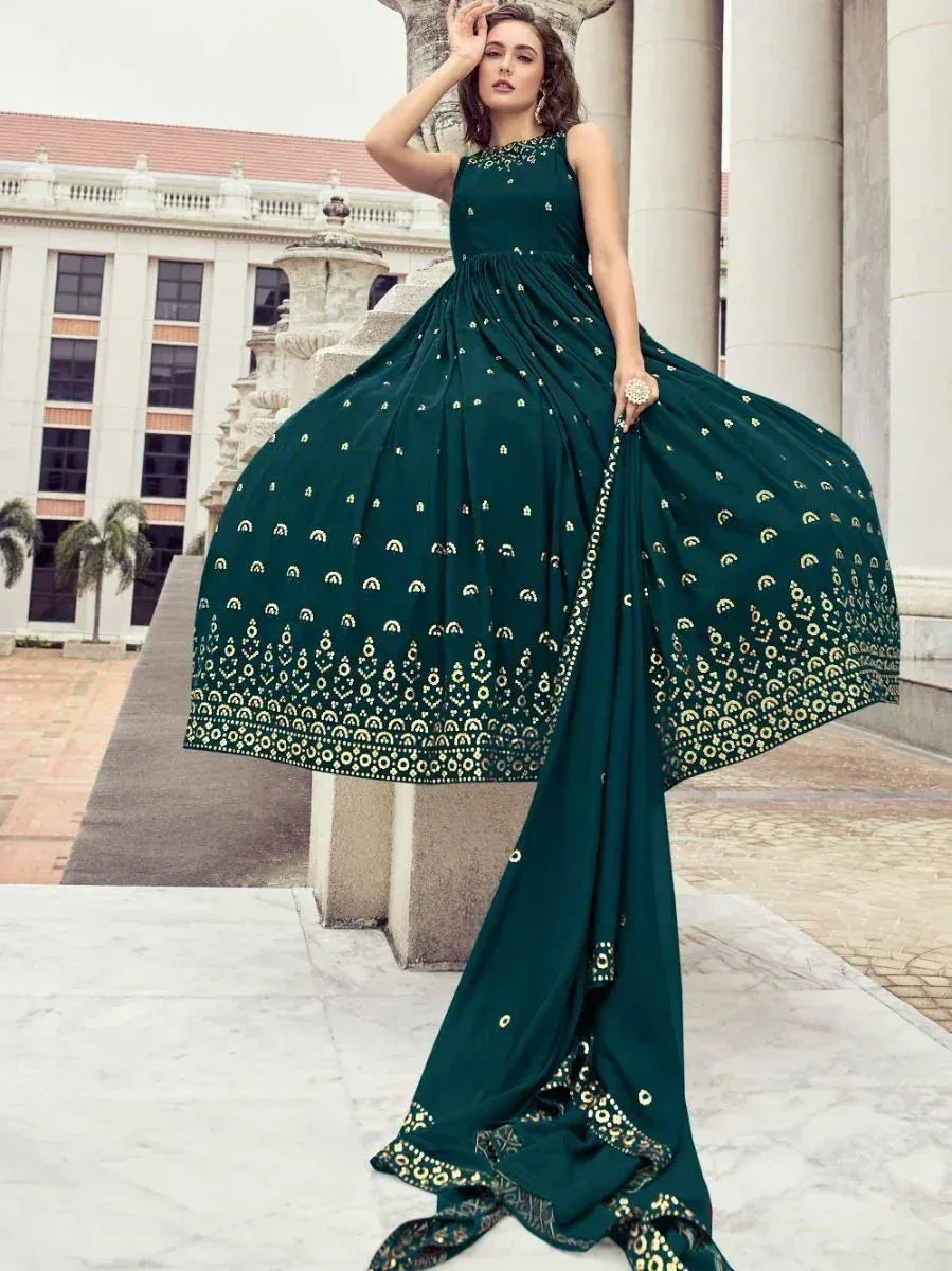 Emerald green ethnic gown with gold embroidery, perfect for Indian weddings and festive occasions.