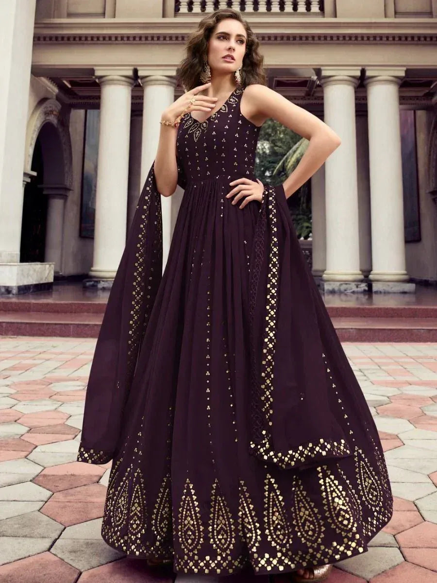 Elegant dark purple ethnic gown with gold embroidery, perfect for Indian weddings and festive occasions.