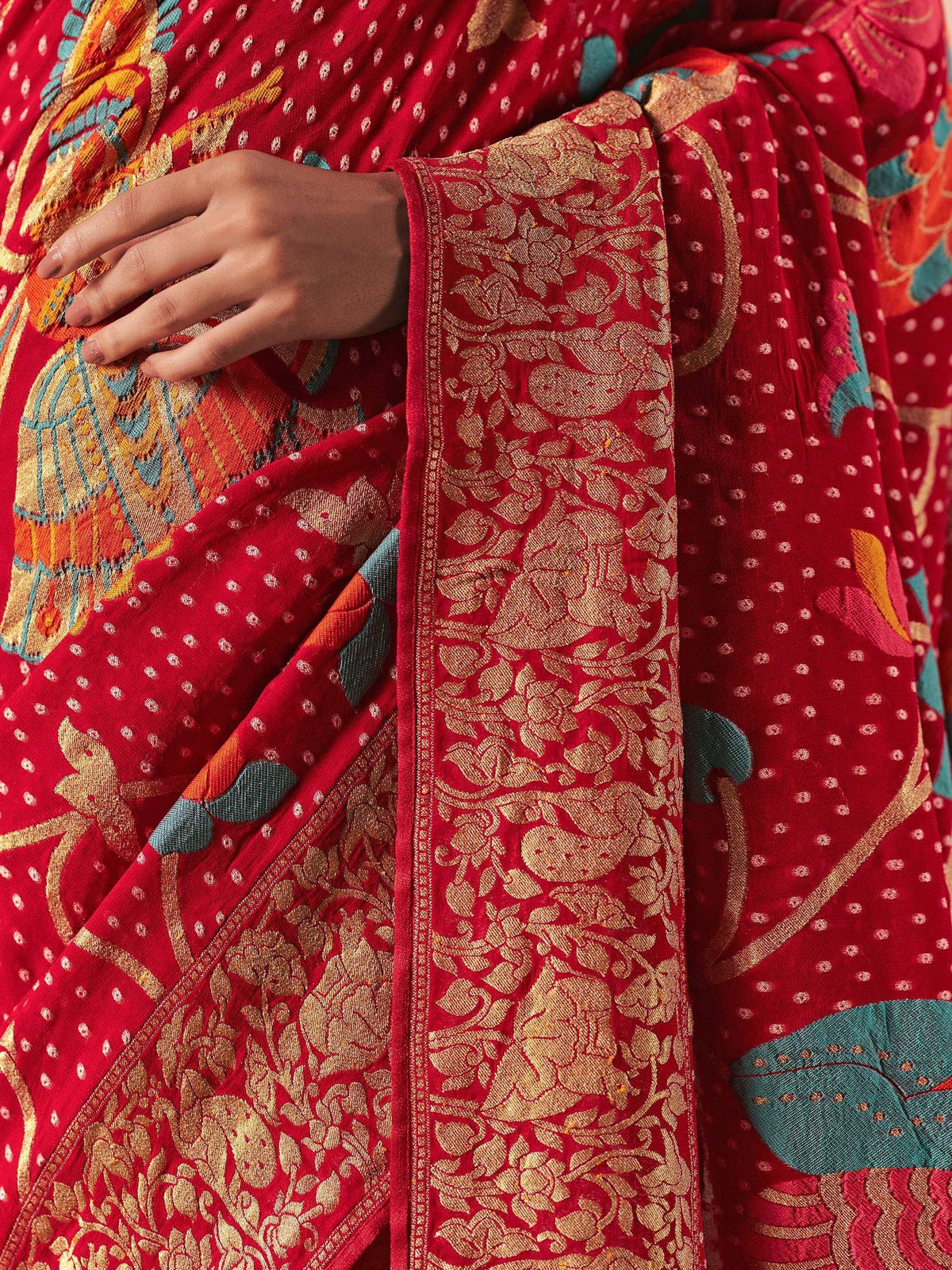 Red ethnic saree with gold floral embroidery and colorful motifs