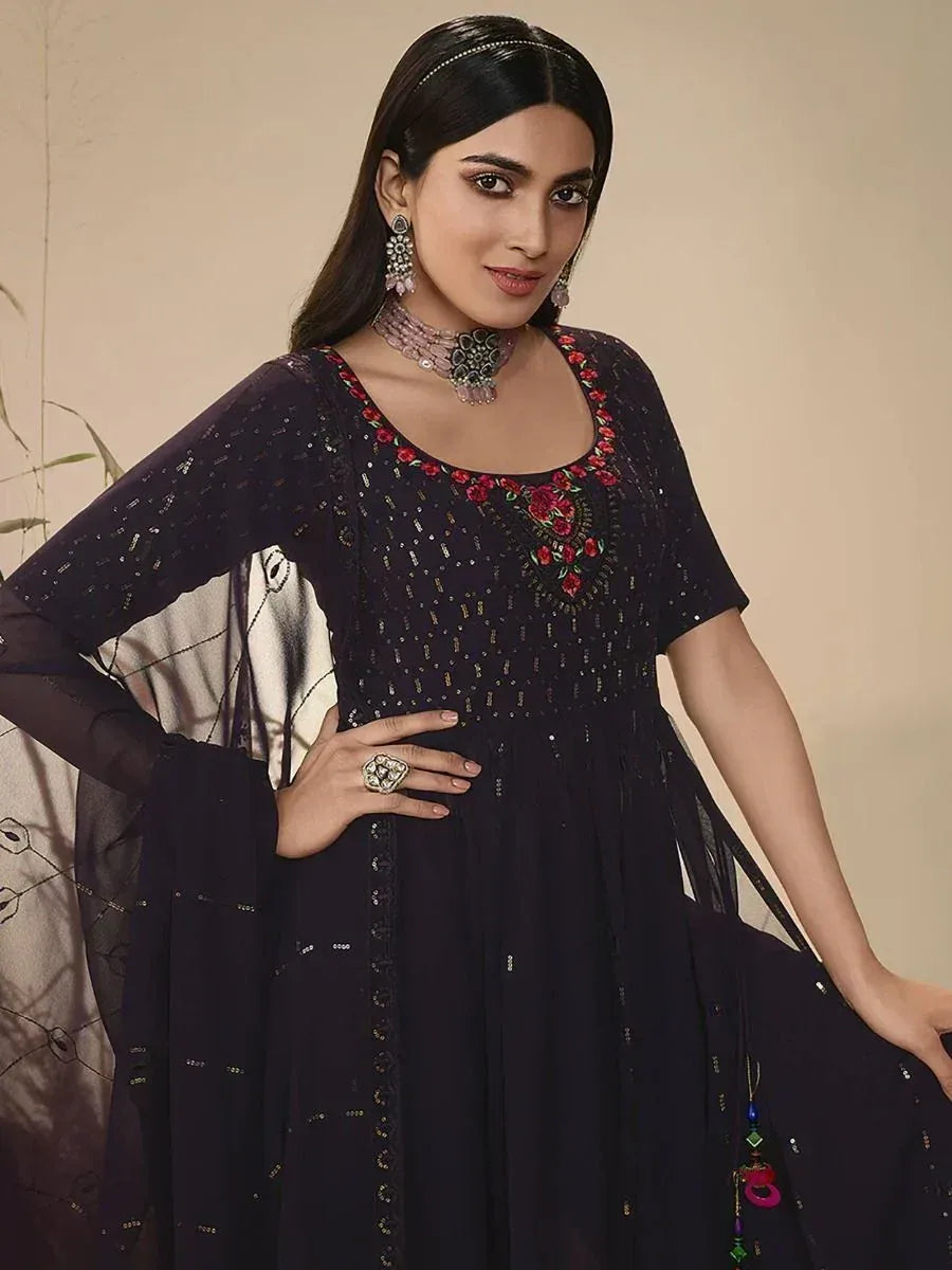 Woman in a navy blue ethnic gown with floral embroidery and sheer dupatta