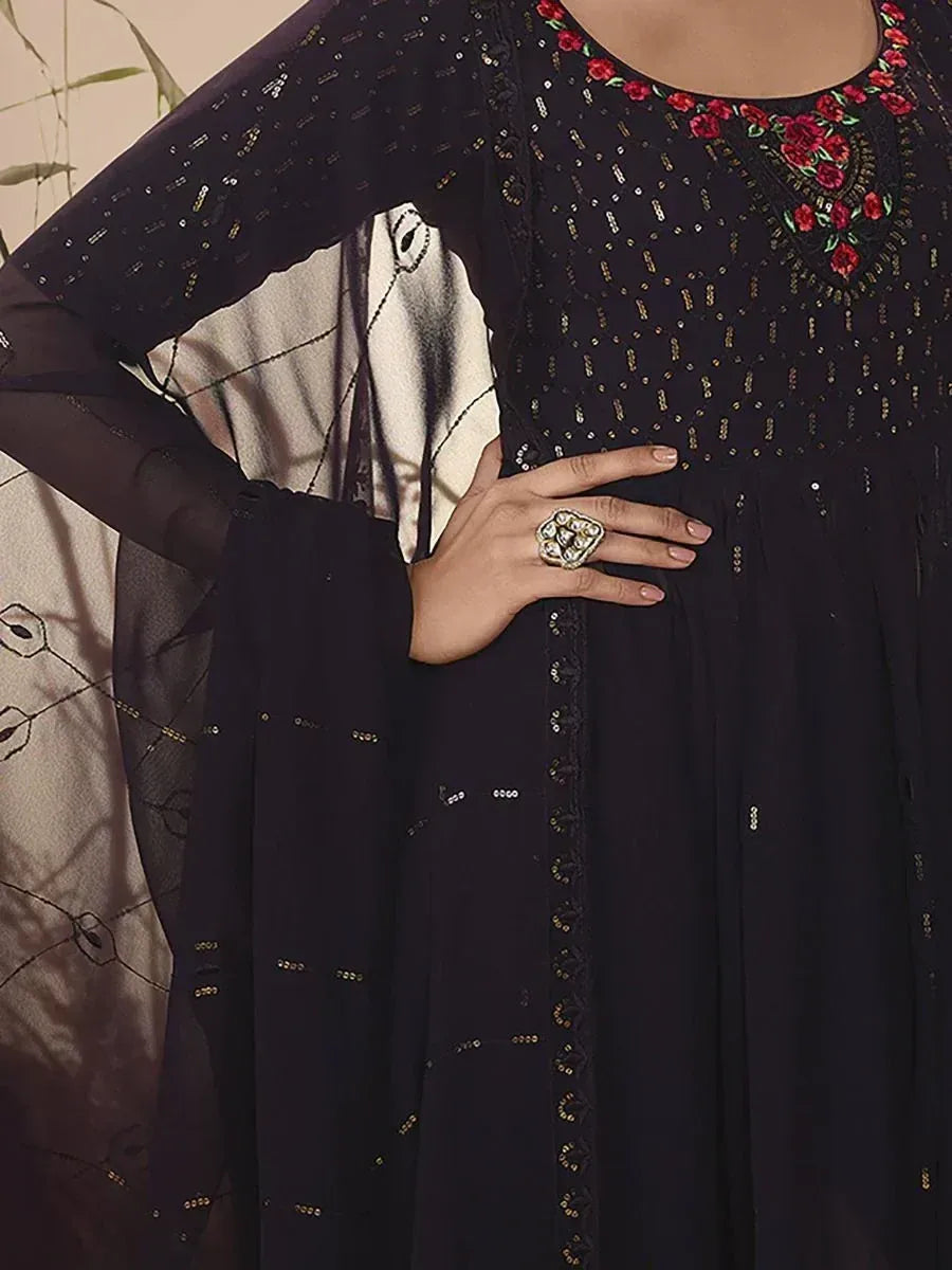 Close-up of black ethnic gown with gold sequin work and red floral embroidery