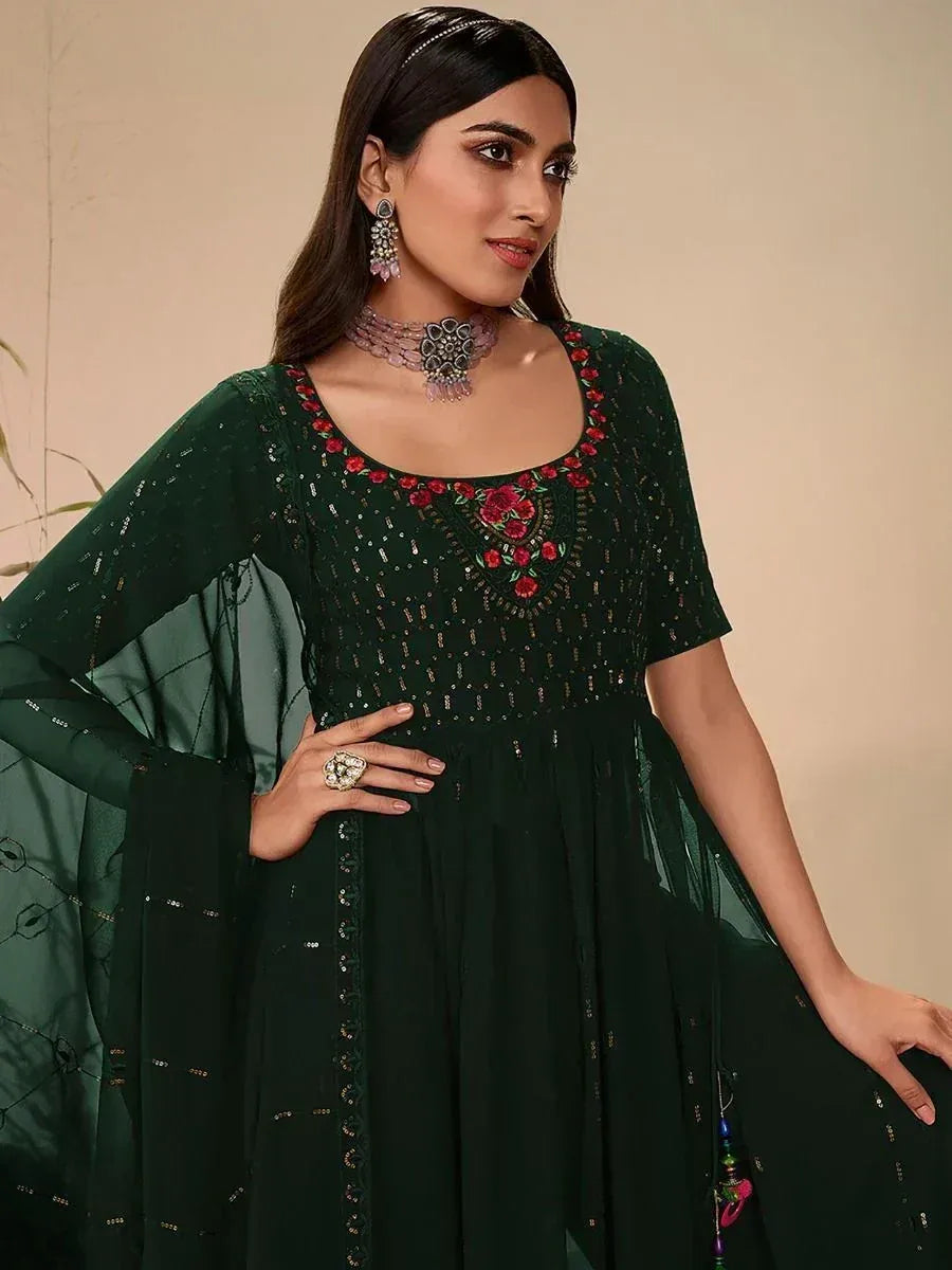 Woman wearing dark green ethnic gown with floral embroidery and sequin embellishments