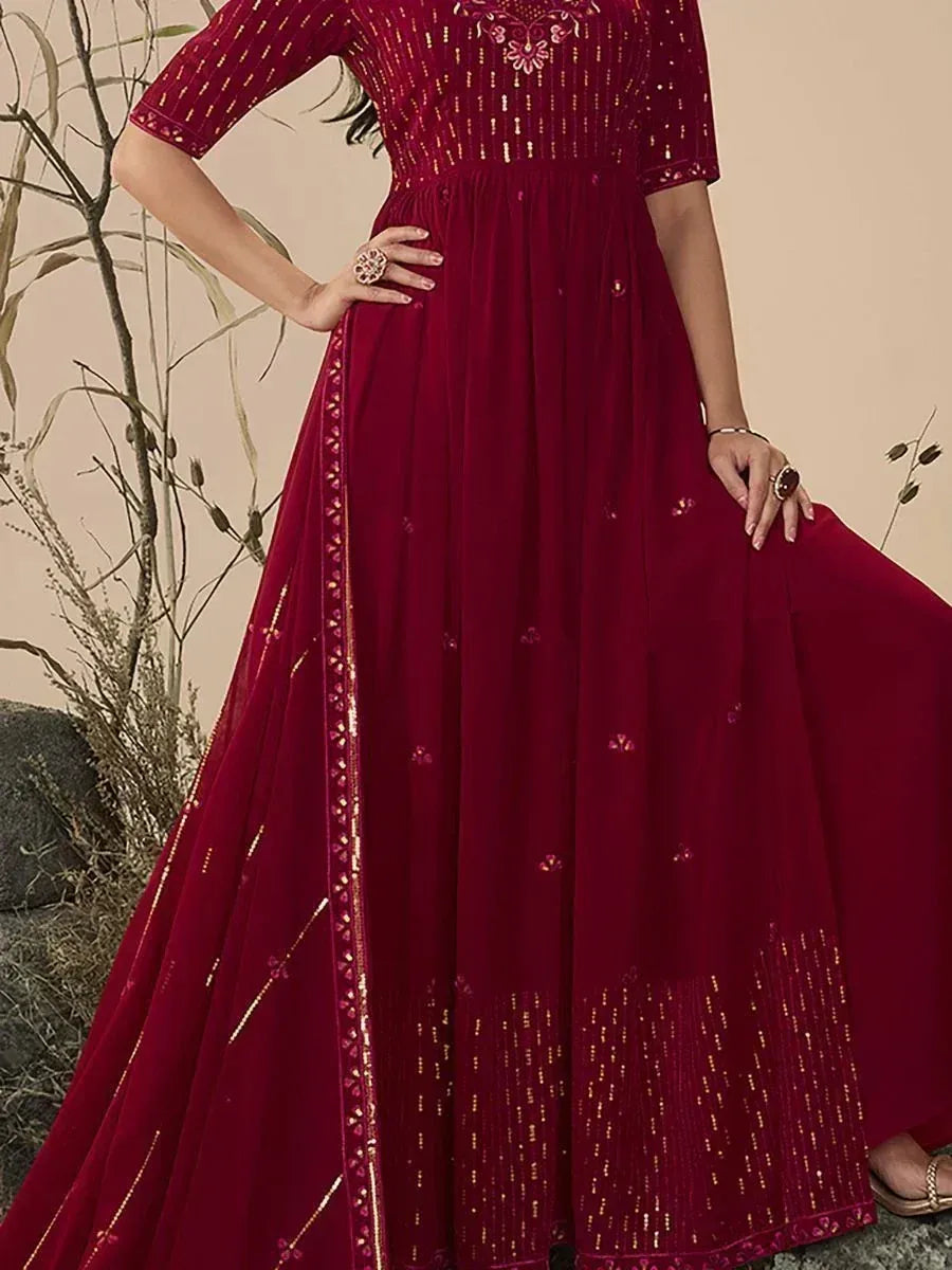 Woman wearing maroon embroidered ethnic gown with gold detailing and sheer dupatta