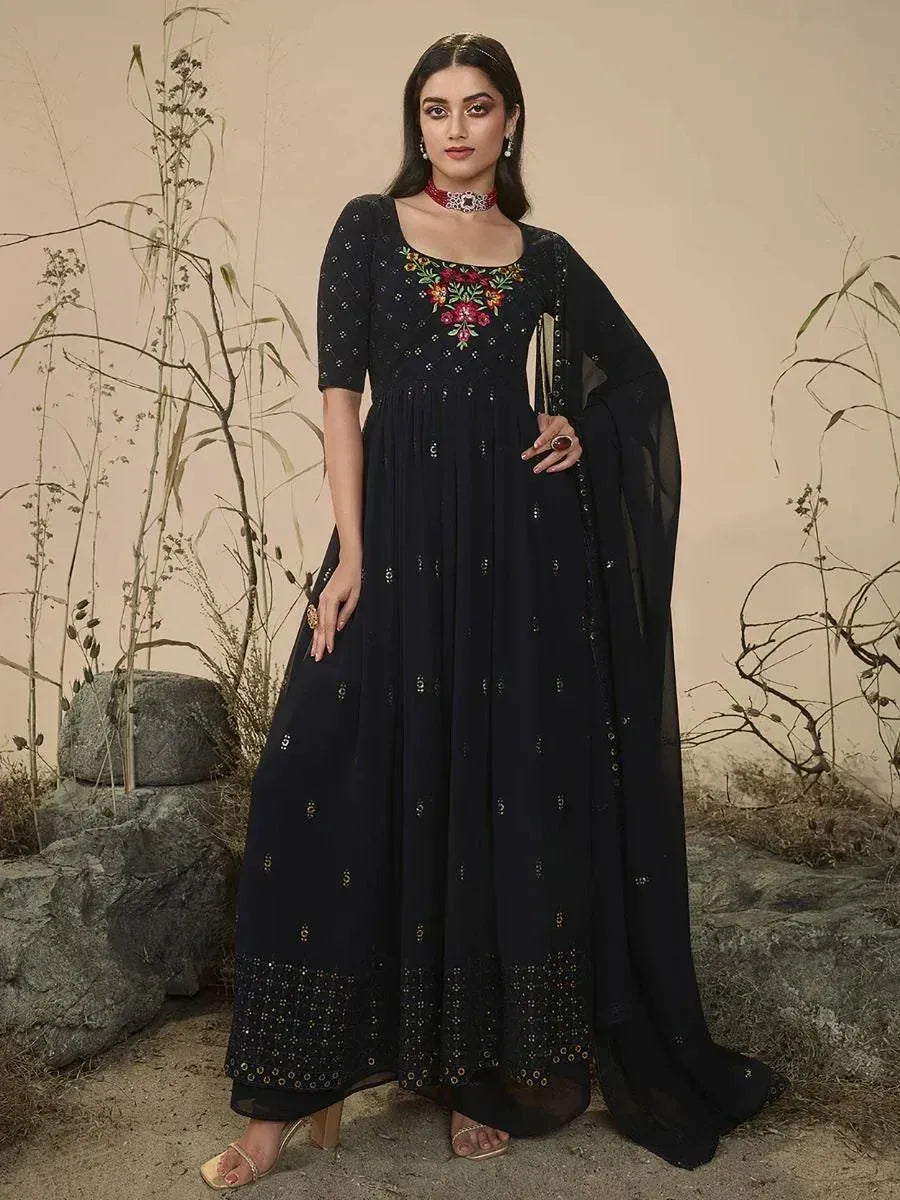 Woman wearing a black embroidered ethnic gown with dupatta, floral and sequin details
