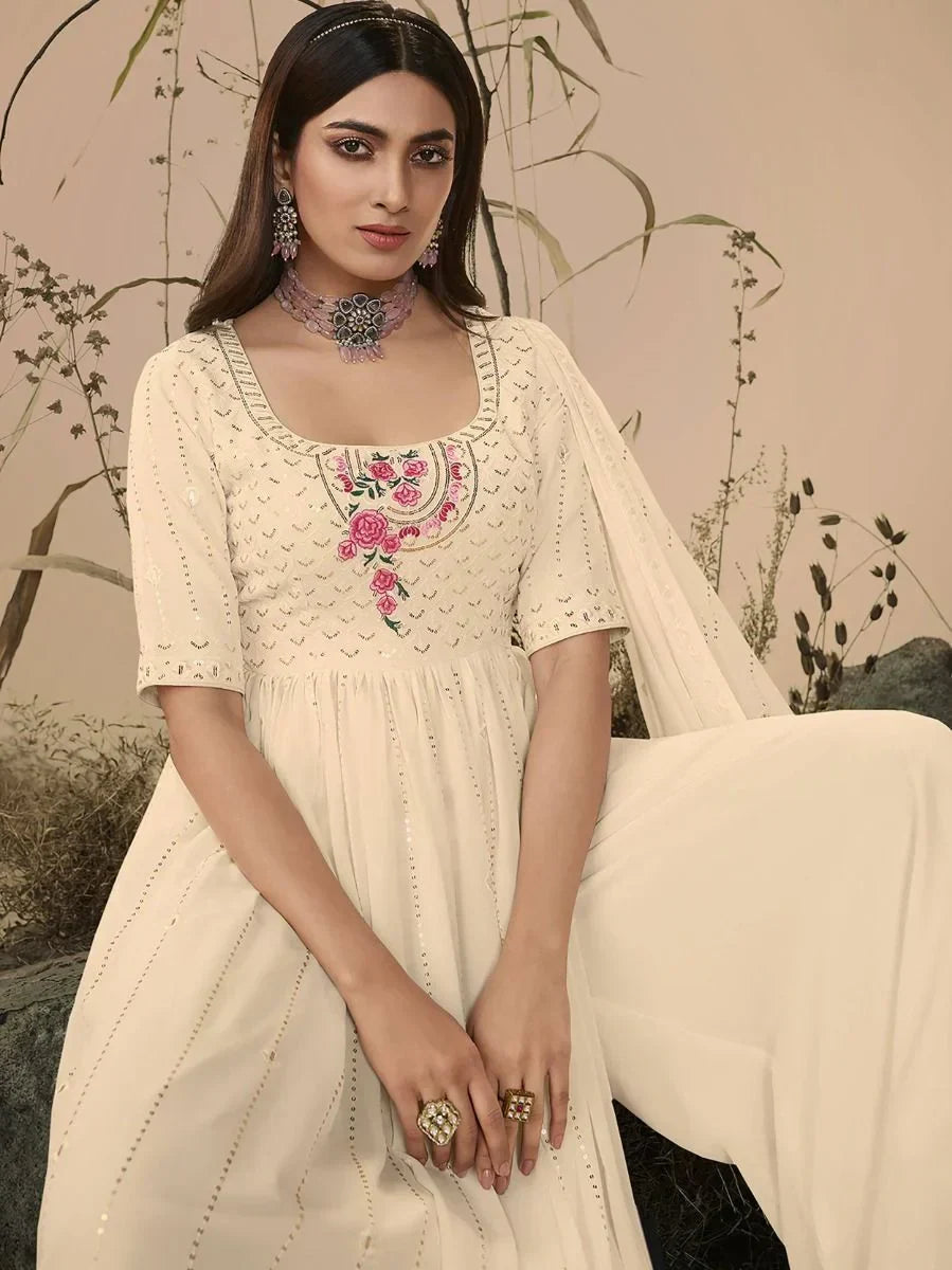 Woman wearing cream ethnic gown with floral embroidery and statement jewelry