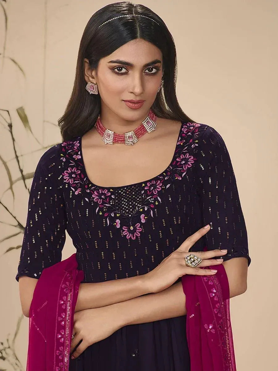 Woman in navy blue embroidered ethnic dress with magenta dupatta and statement jewelry
