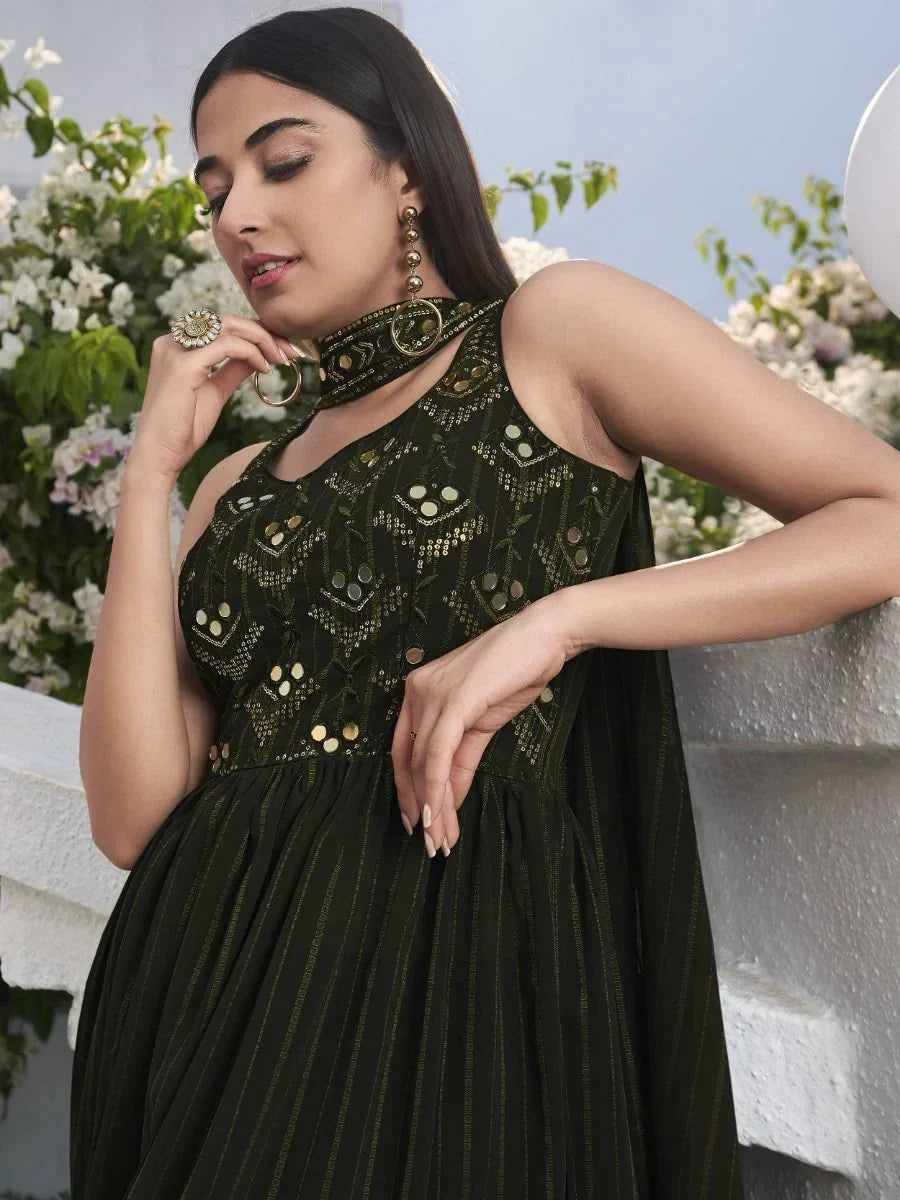 Woman in black embroidered sleeveless Indian ethnic gown with gold jewelry, outdoor setting