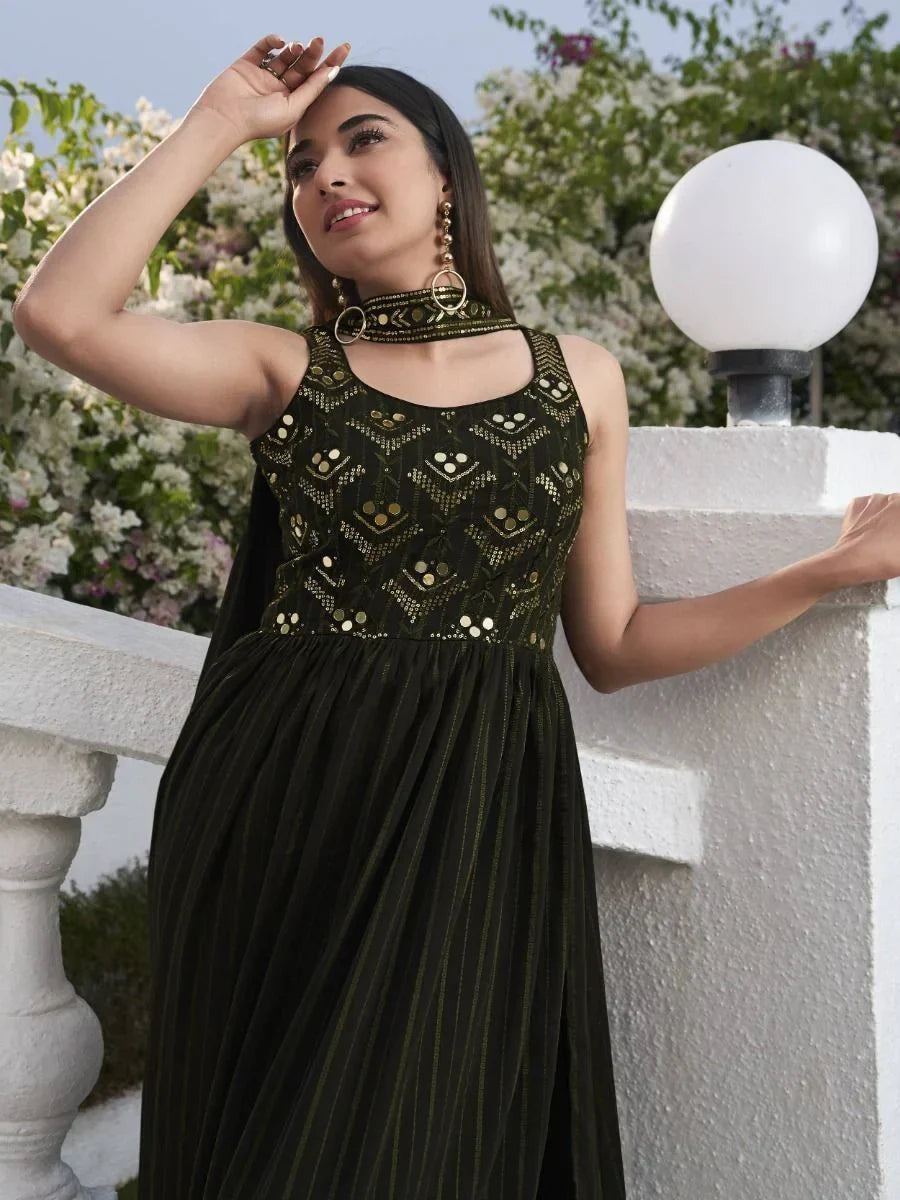 Woman in sleeveless black and gold ethnic gown with geometric embroidery, outdoor setting