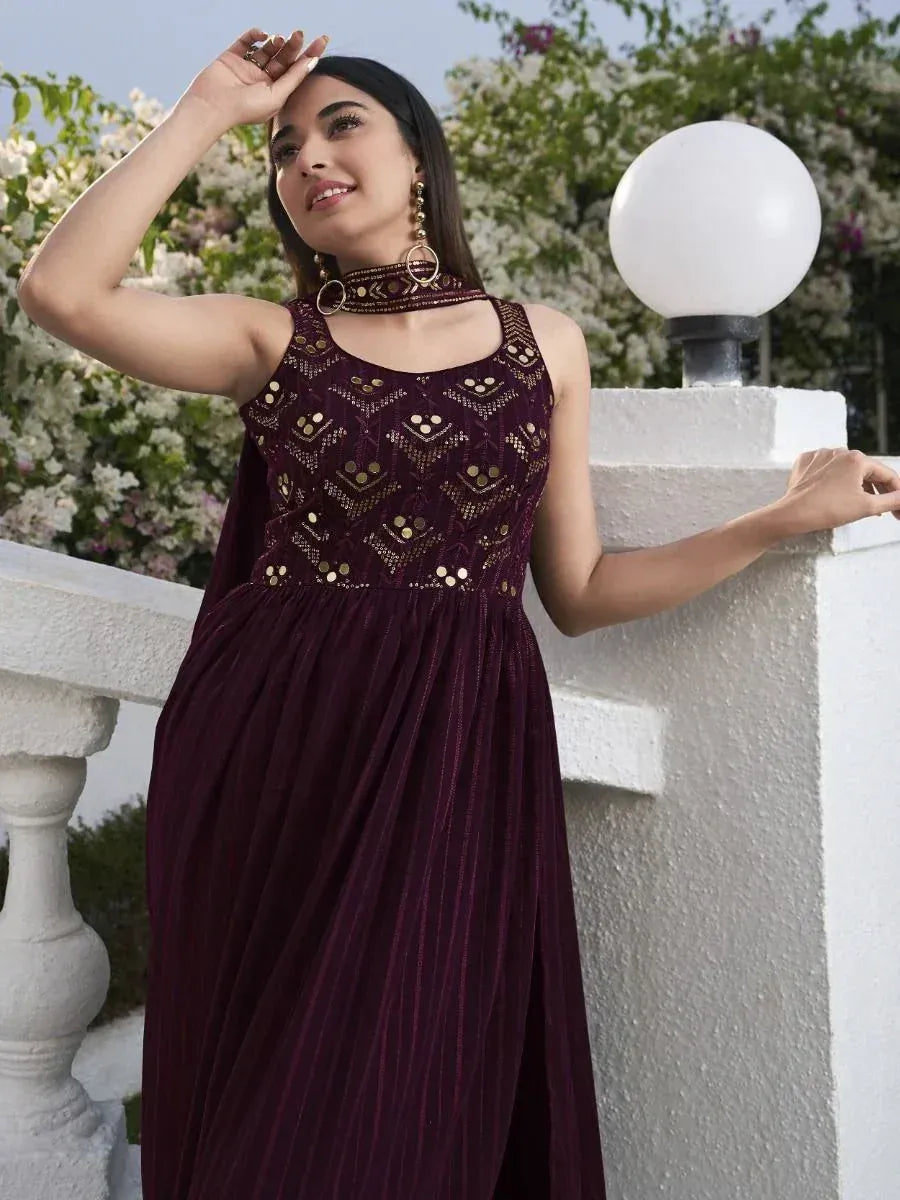 Woman wearing maroon embroidered ethnic gown with gold accents outdoors