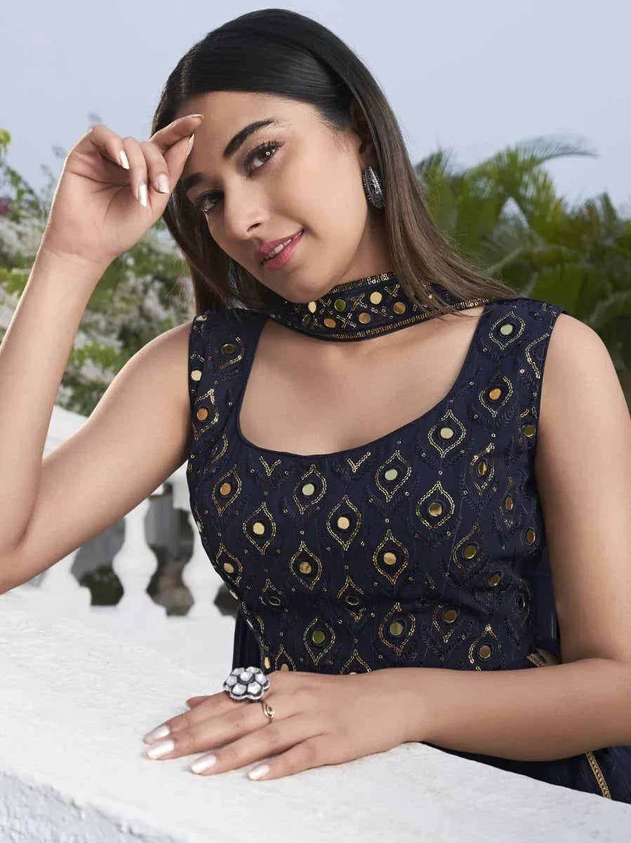 Woman in navy blue embroidered ethnic dress with mirror work, silver jewelry, outdoor setting