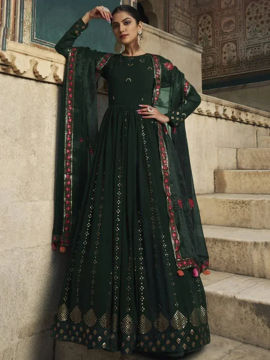 Elegant green ethnic gown with intricate embroidery and mirror work, perfect for festive occasions.