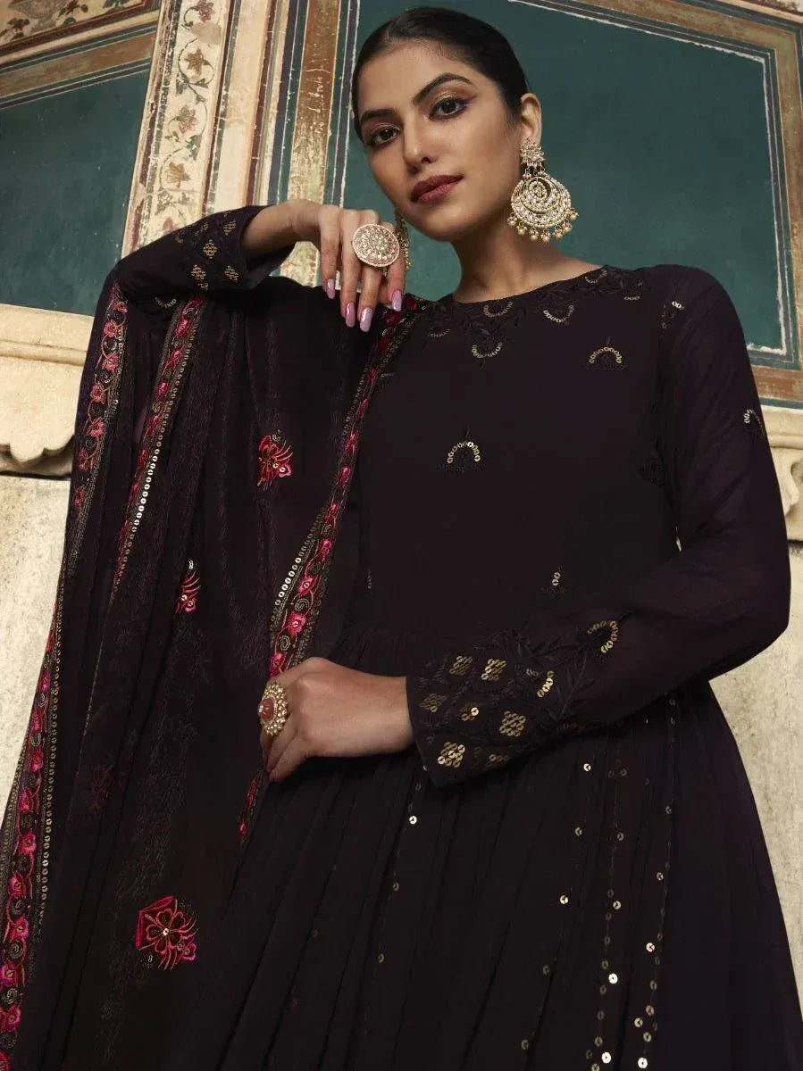 Black embroidered ethnic gown with floral dupatta, gold embellishments, and statement jewelry for festive occasions
