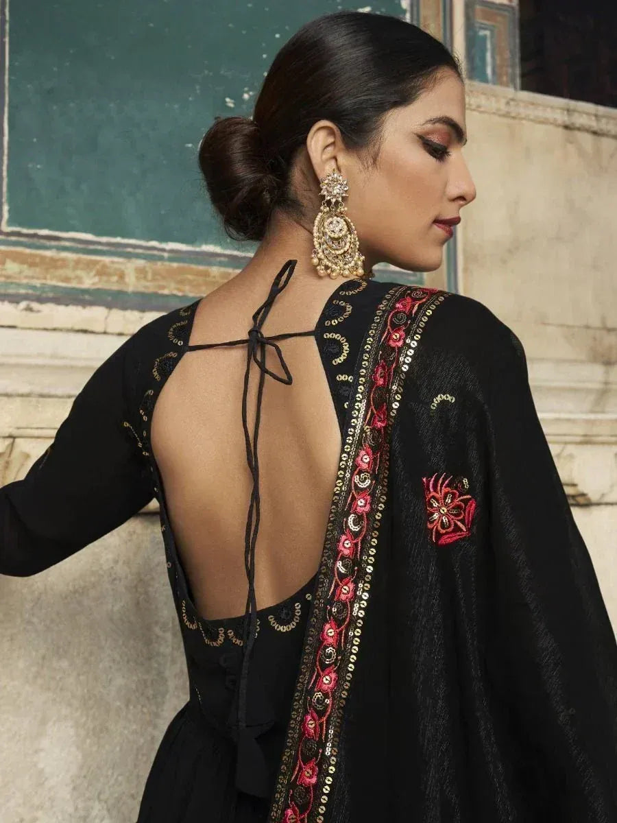 Black ethnic gown with back tie and red embroidery, paired with traditional earrings