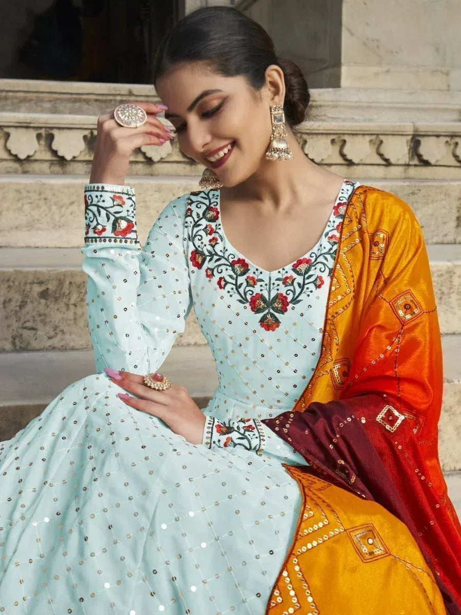 Woman in light blue embroidered anarkali with orange dupatta, floral motifs and sequins, Indian ethnic wear