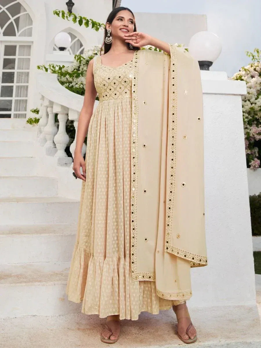 Woman wearing elegant beige ethnic gown with gold embroidery and matching dupatta