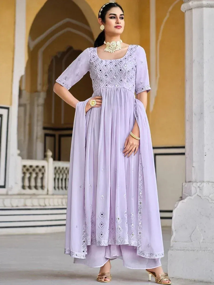 Woman in pastel lavender embroidered Anarkali suit with dupatta, traditional jewelry, indoors
