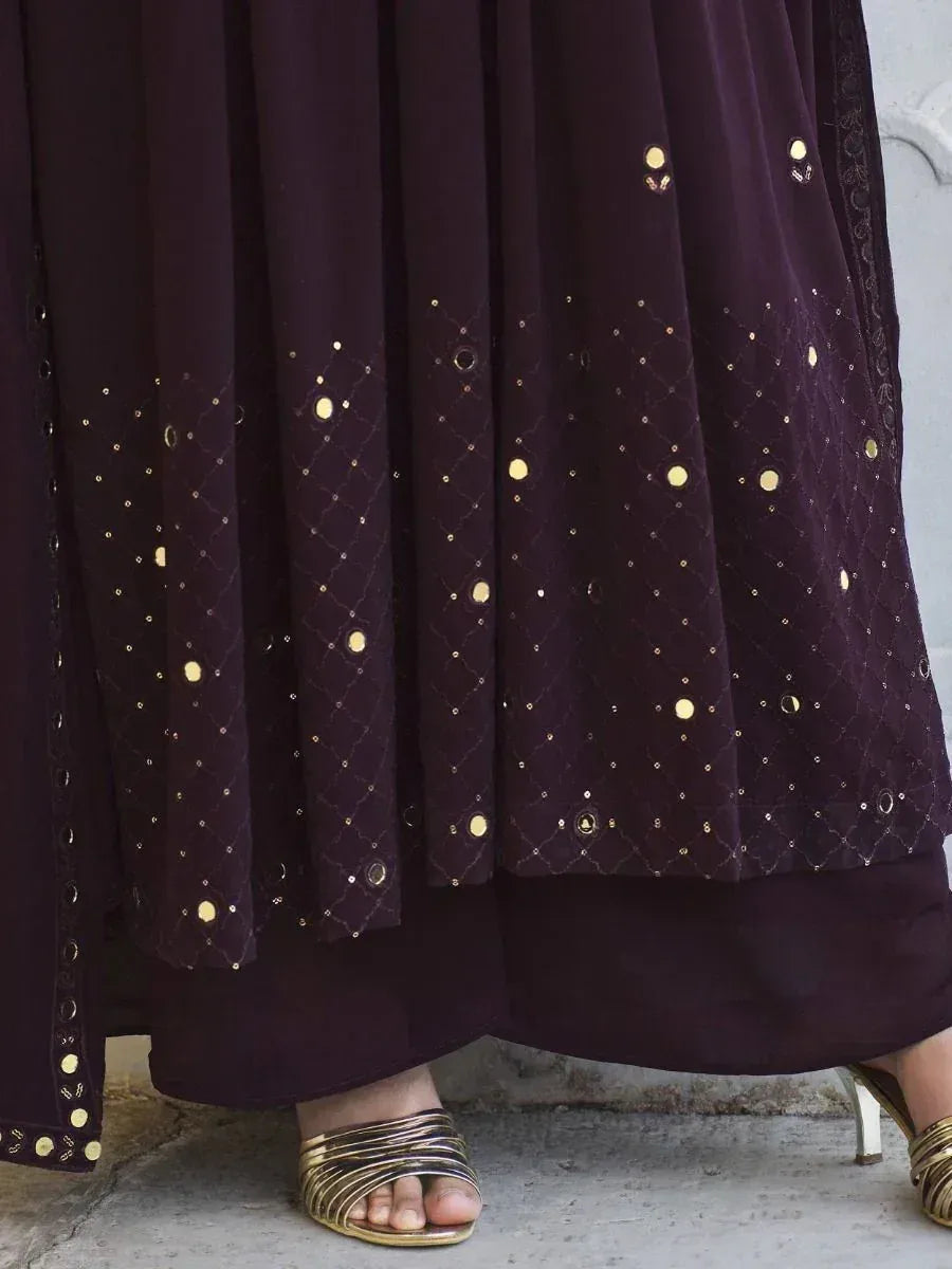 Purple embroidered ethnic gown with sequin accents, gold heels visible on concrete floor