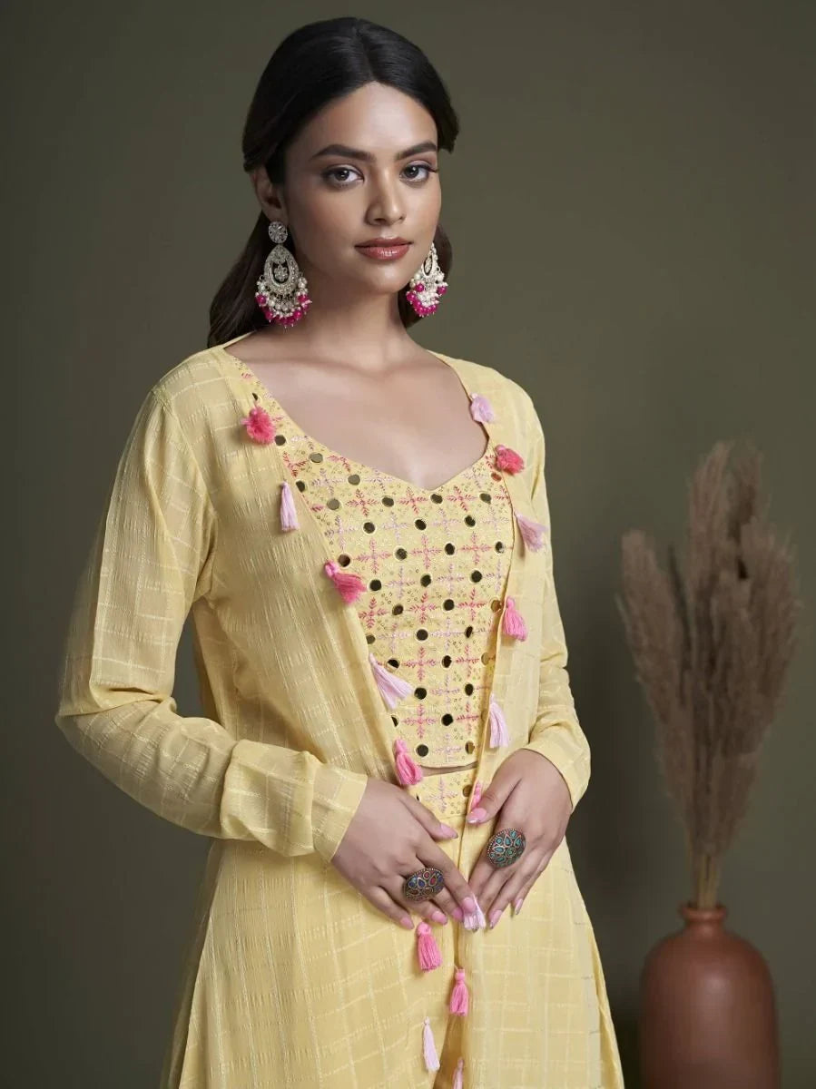 Woman in yellow ethnic kurti with pink tassels, statement earrings and rings