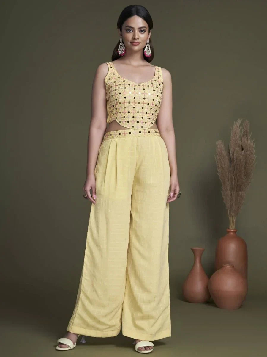 Woman wearing yellow mirror work crop top and wide leg palazzo pants, Indian ethnic outfit