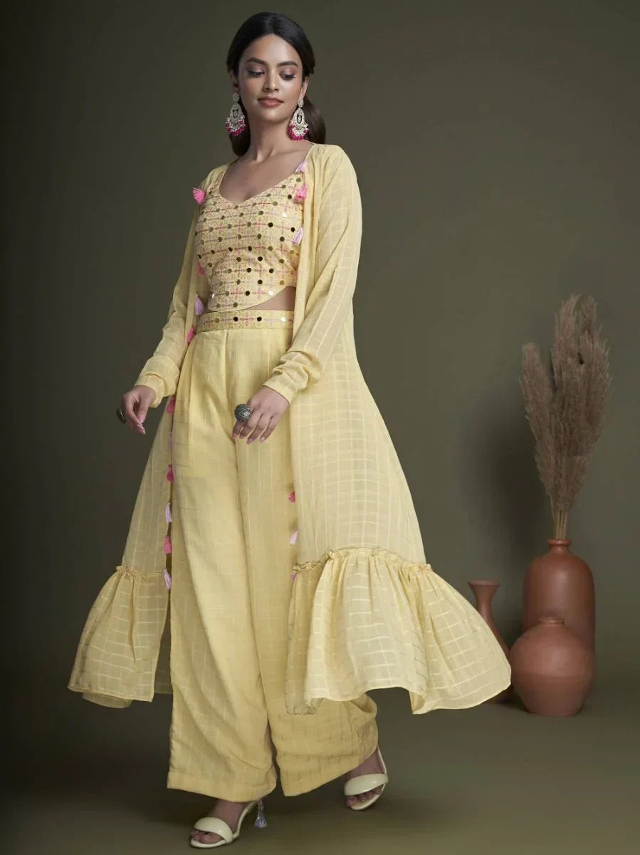 Woman wearing a yellow ethnic kurta set with flared sleeves and wide-leg pants, festive attire