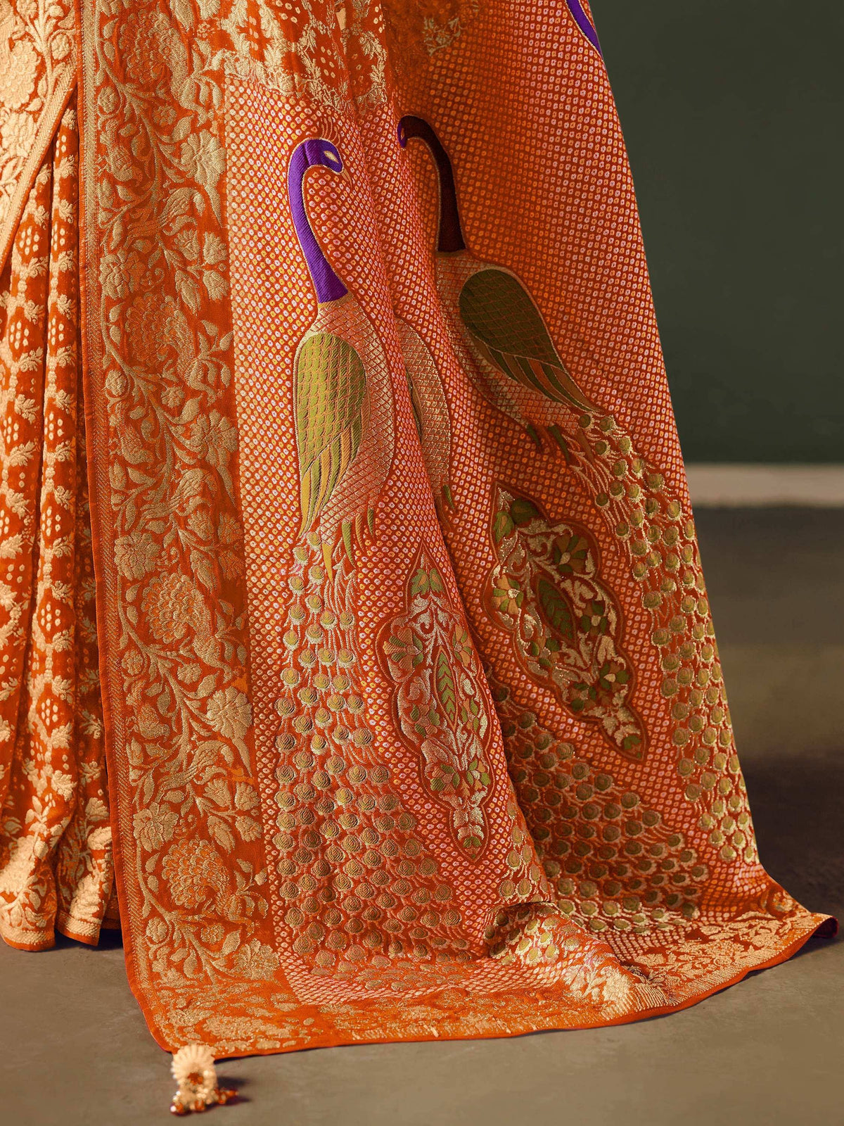 Orange ethnic saree with peacock embroidery and golden floral patterns
