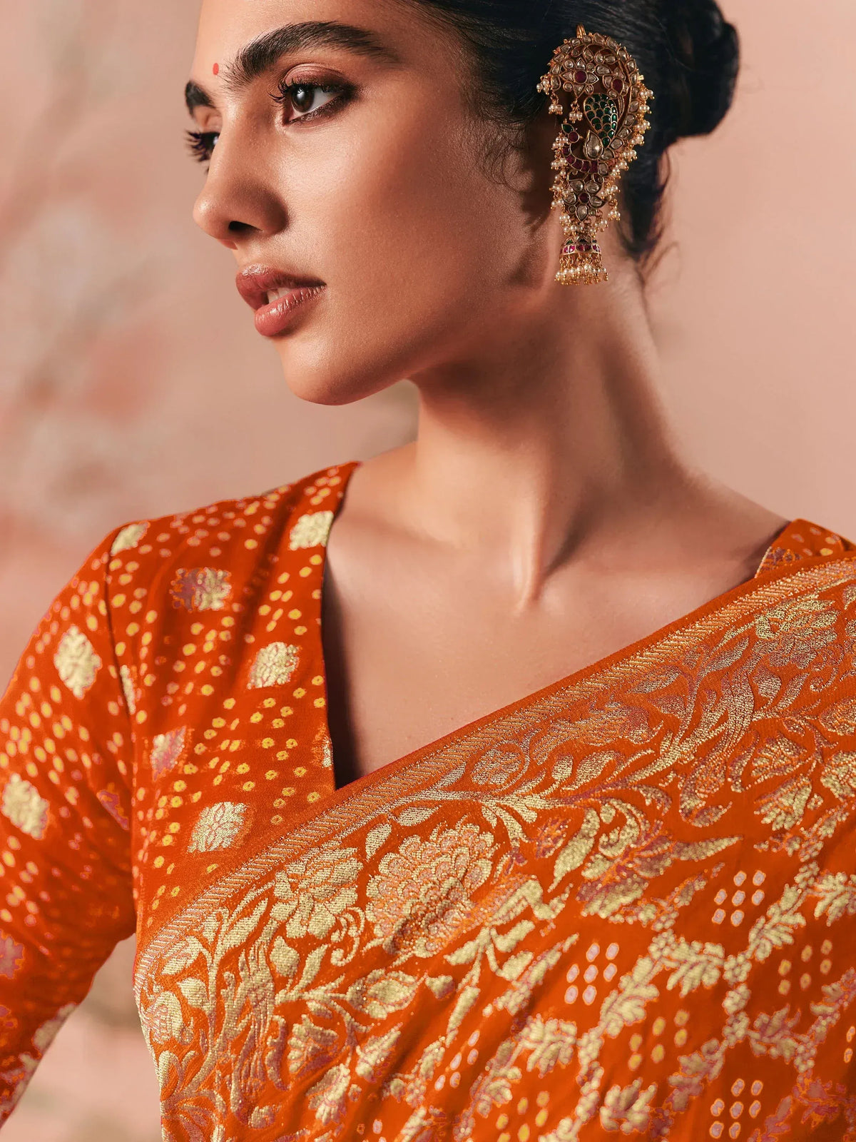 Orange floral saree with gold embroidery and traditional jhumka earrings
