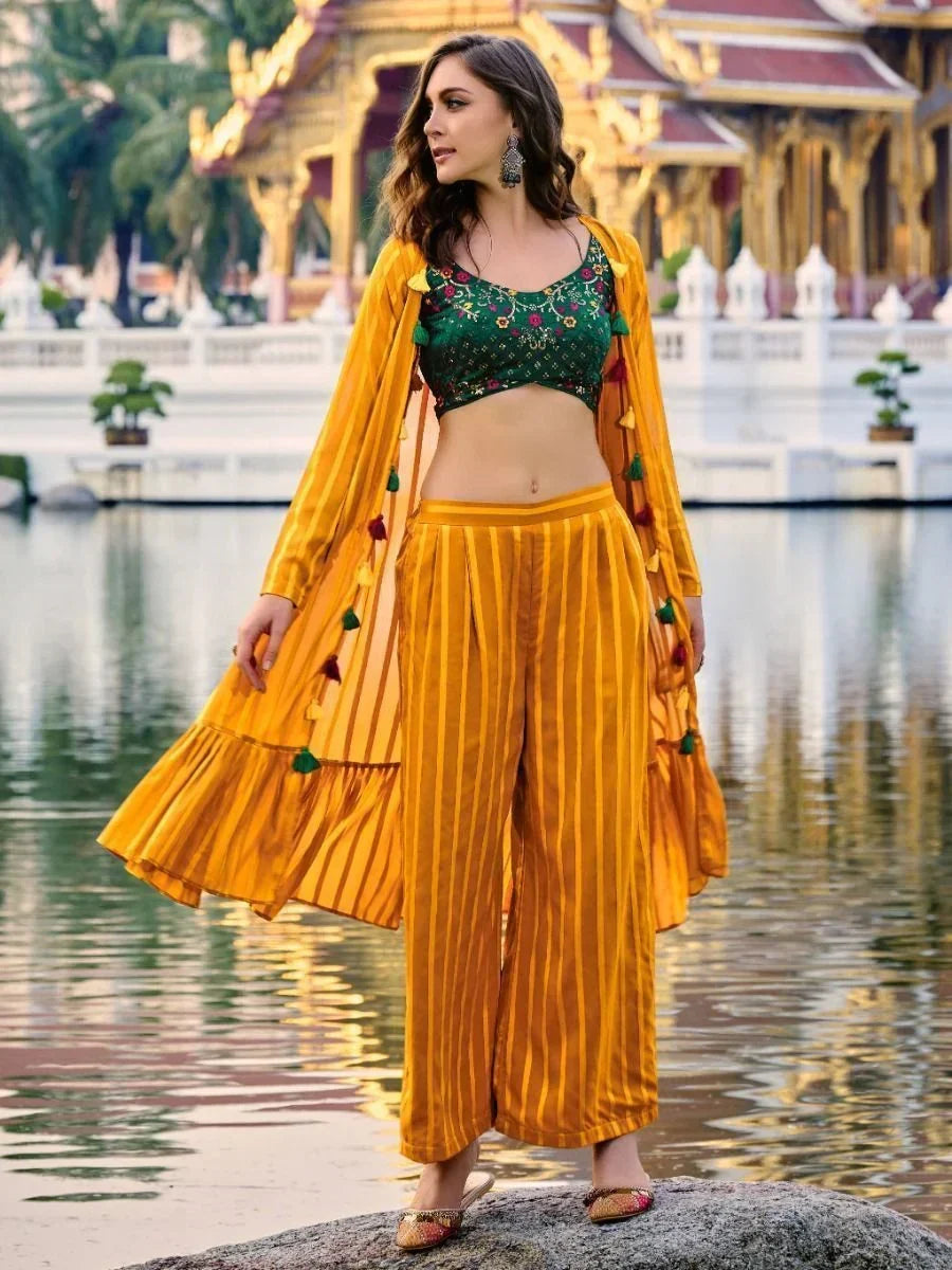 Woman wearing a yellow striped ethnic jacket and pants with green floral crop top outdoors