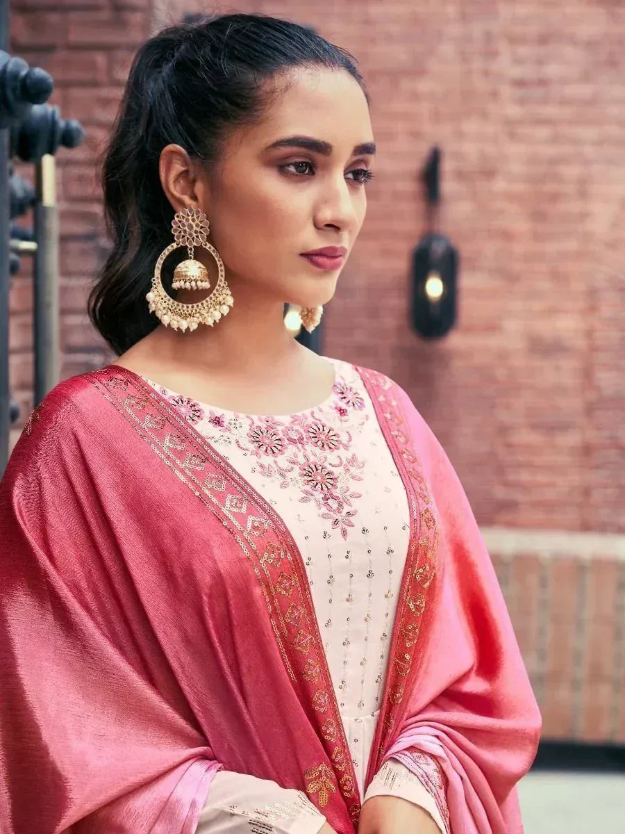 Woman in elegant ethnic salwar kameez with pink dupatta and statement earrings