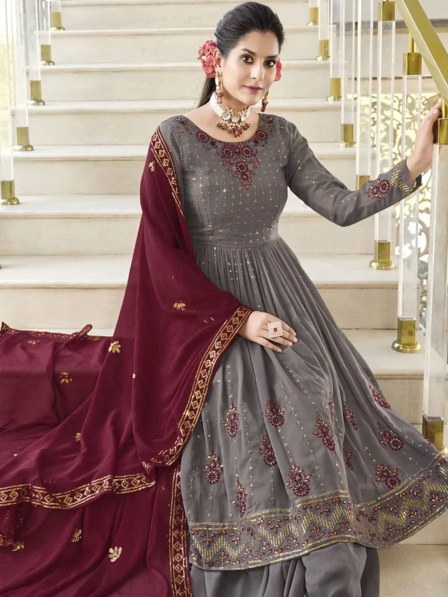 Woman in a grey embroidered anarkali suit with maroon dupatta, traditional Indian attire