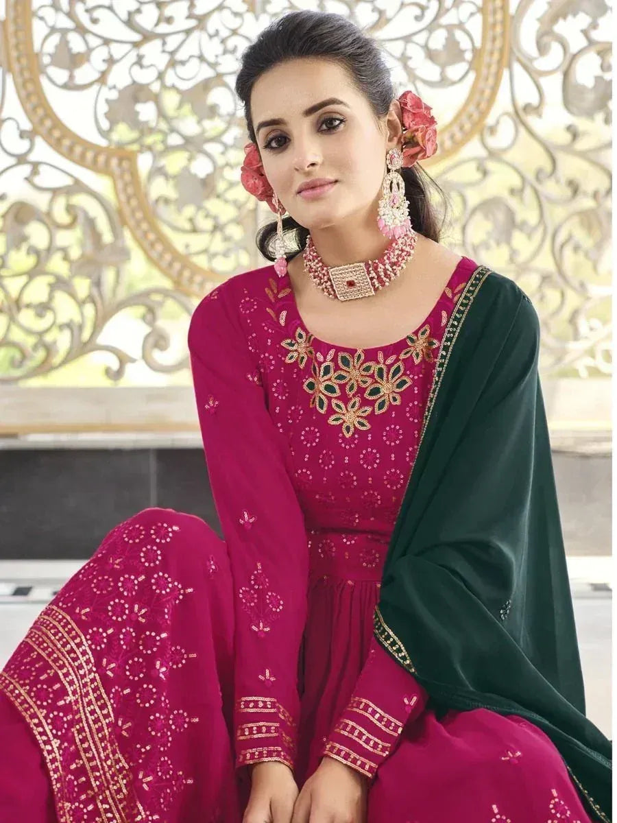 Woman in magenta embroidered ethnic gown with green dupatta and floral jewelry
