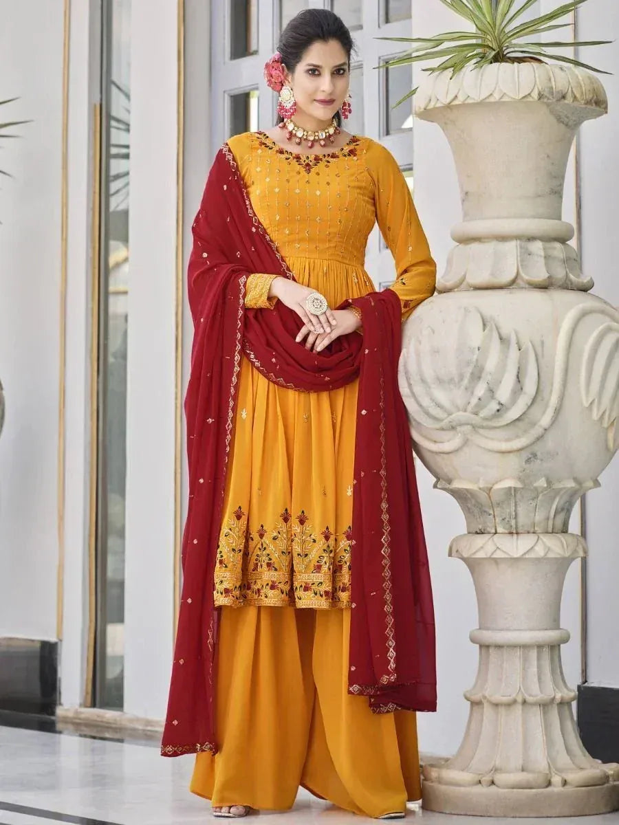 Woman in mustard yellow and maroon embroidered palazzo salwar kameez with floral dupatta