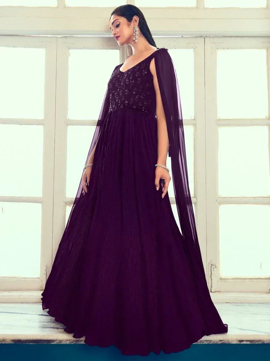 Elegant purple ethnic gown with cape sleeve, pleated skirt, and embellished bodice for festive occasions