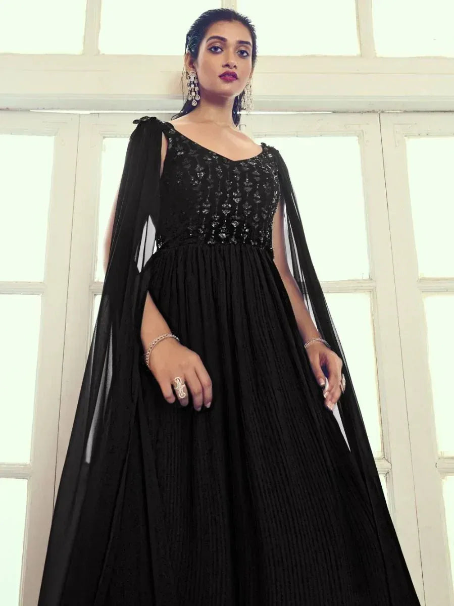 Black ethnic gown with sequin bodice and sheer cape, perfect for Indian weddings or parties.