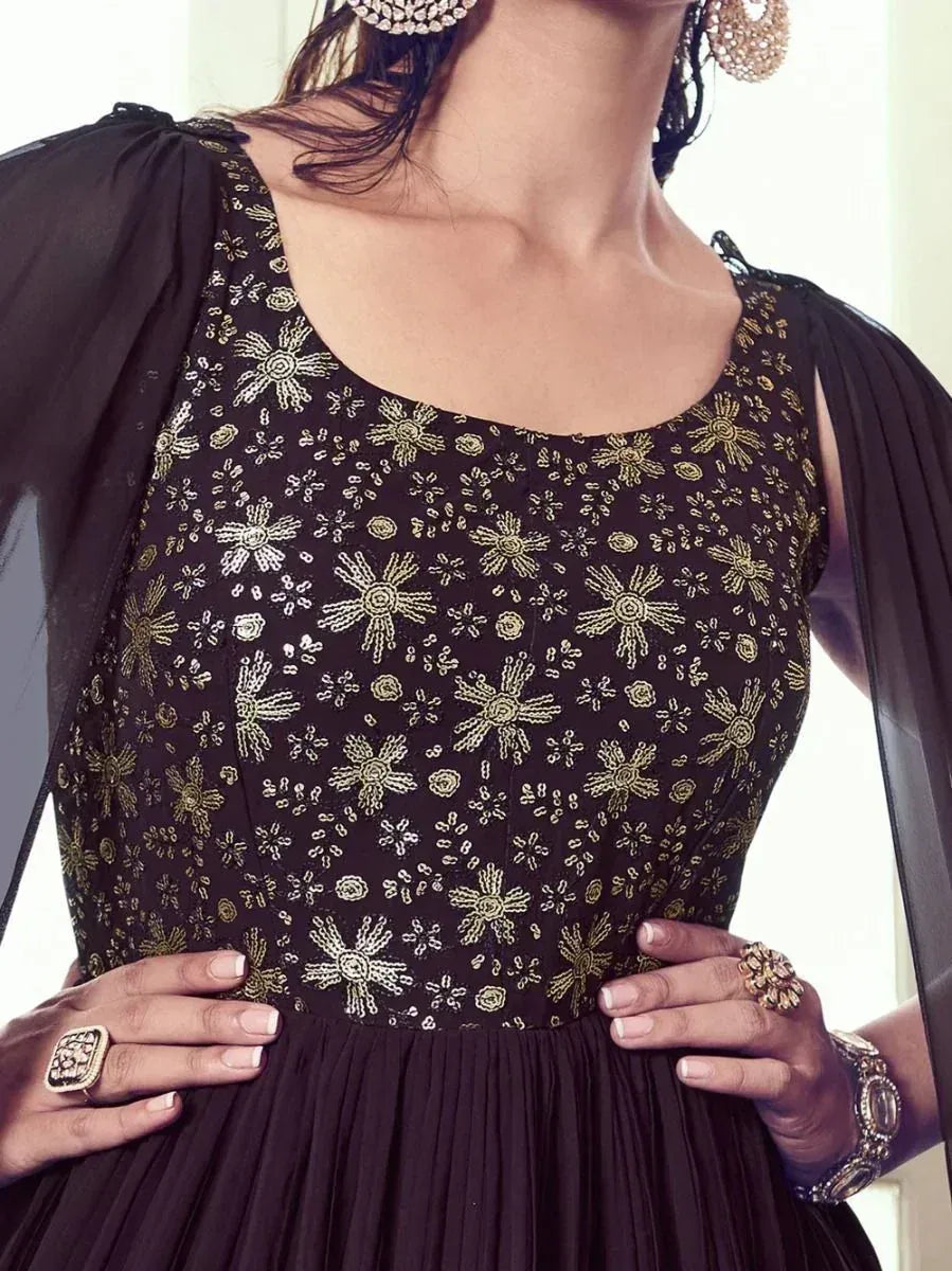 Black ethnic gown with gold floral embroidery, pleated skirt, and sheer sleeves for Indian occasions