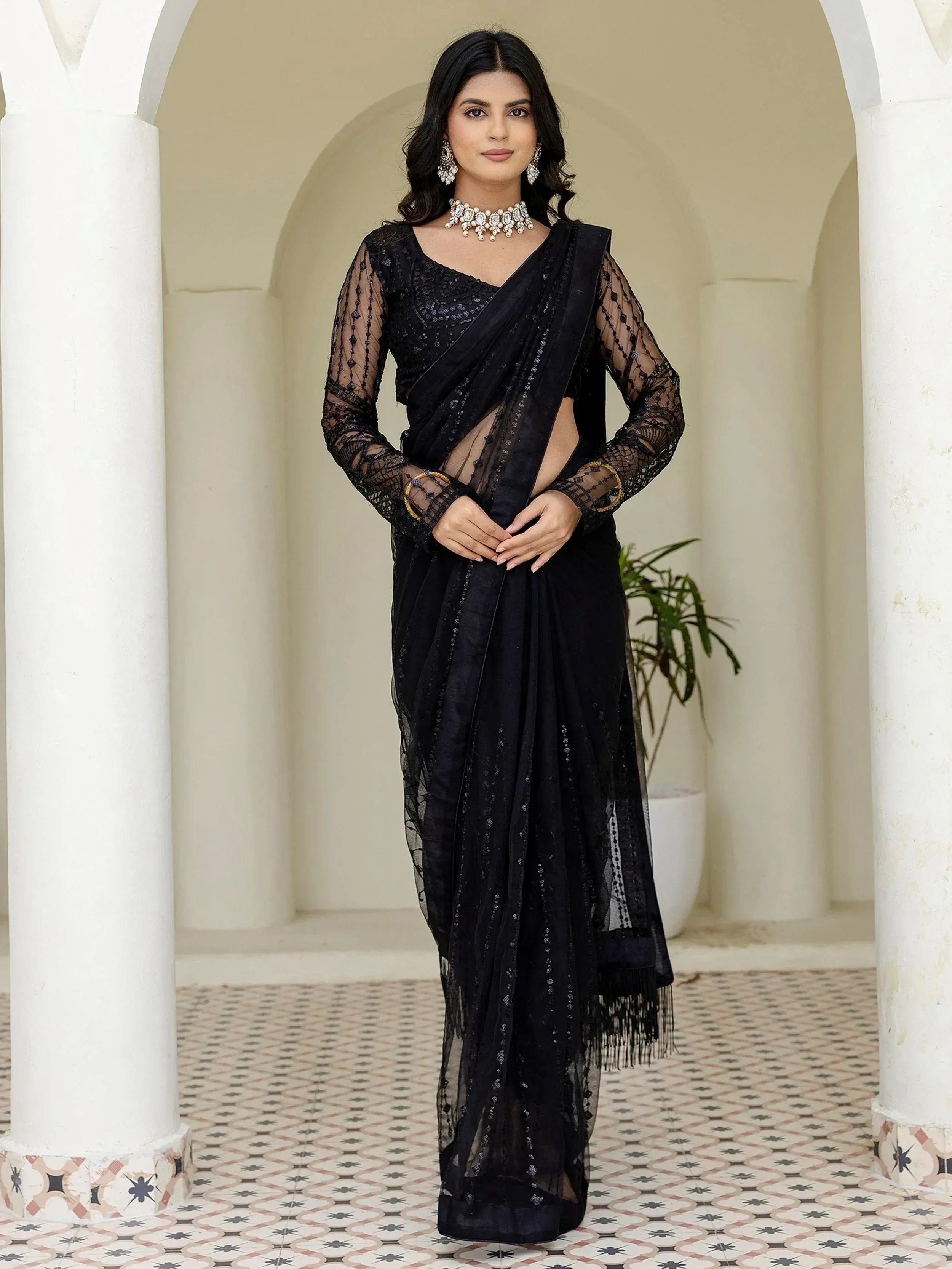 Black sheer saree with sequin work and lace sleeves, styled with statement jewelry for ethnic occasions
