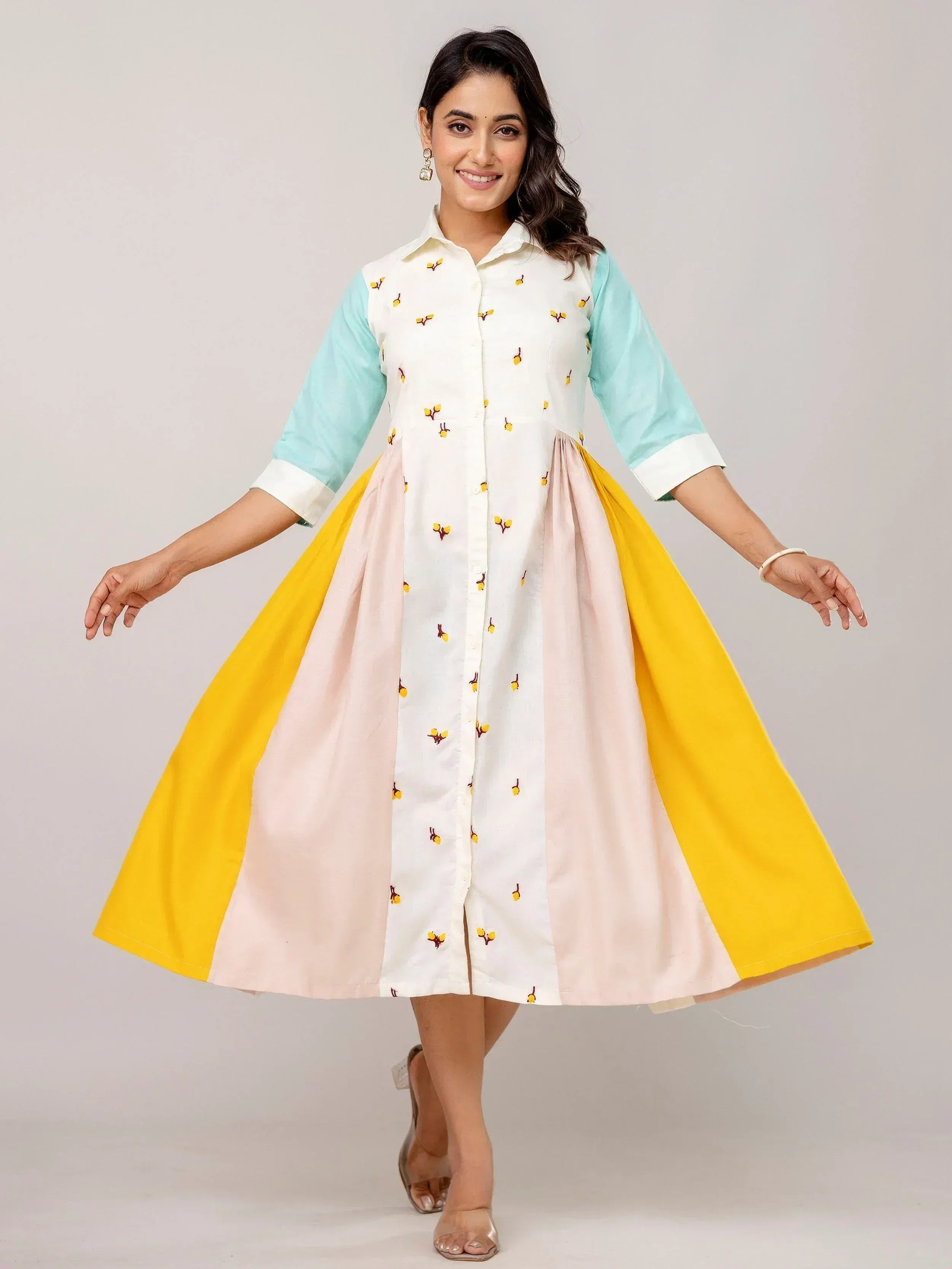 Woman in colorful embroidered ethnic gown with pastel sleeves and flared skirt, perfect for Indian occasions.