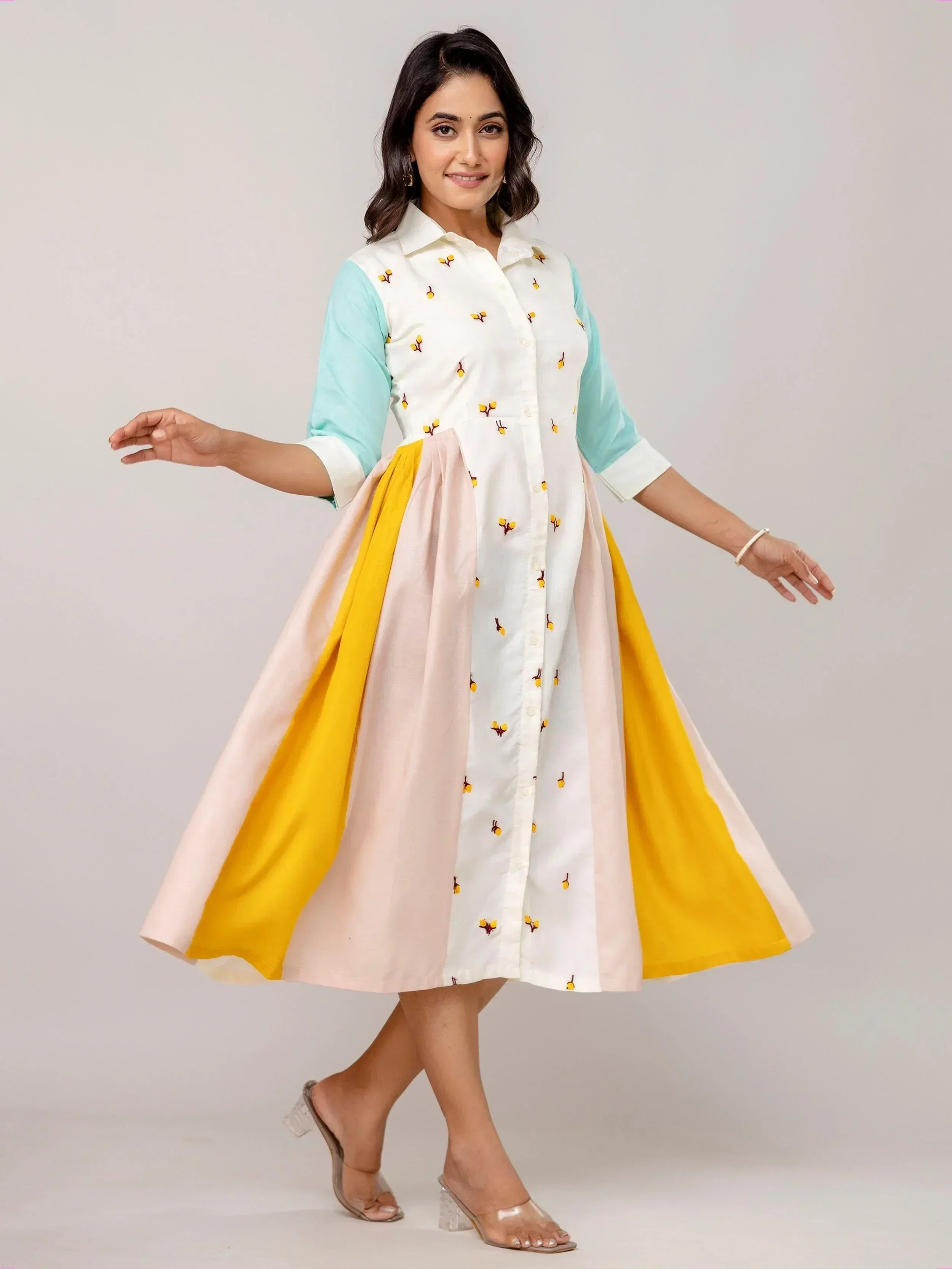 Woman in colorful embroidered ethnic gown with pastel sleeves and yellow-pink skirt, perfect for festive occasions