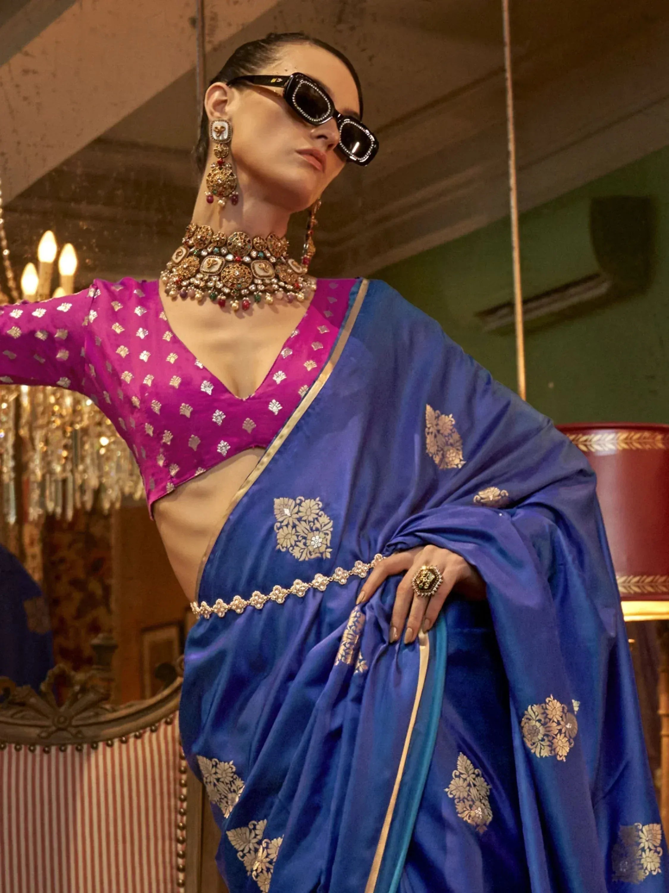 Blue silk saree with gold floral embroidery, paired with pink blouse and traditional jewelry for Indian ethnic wear.