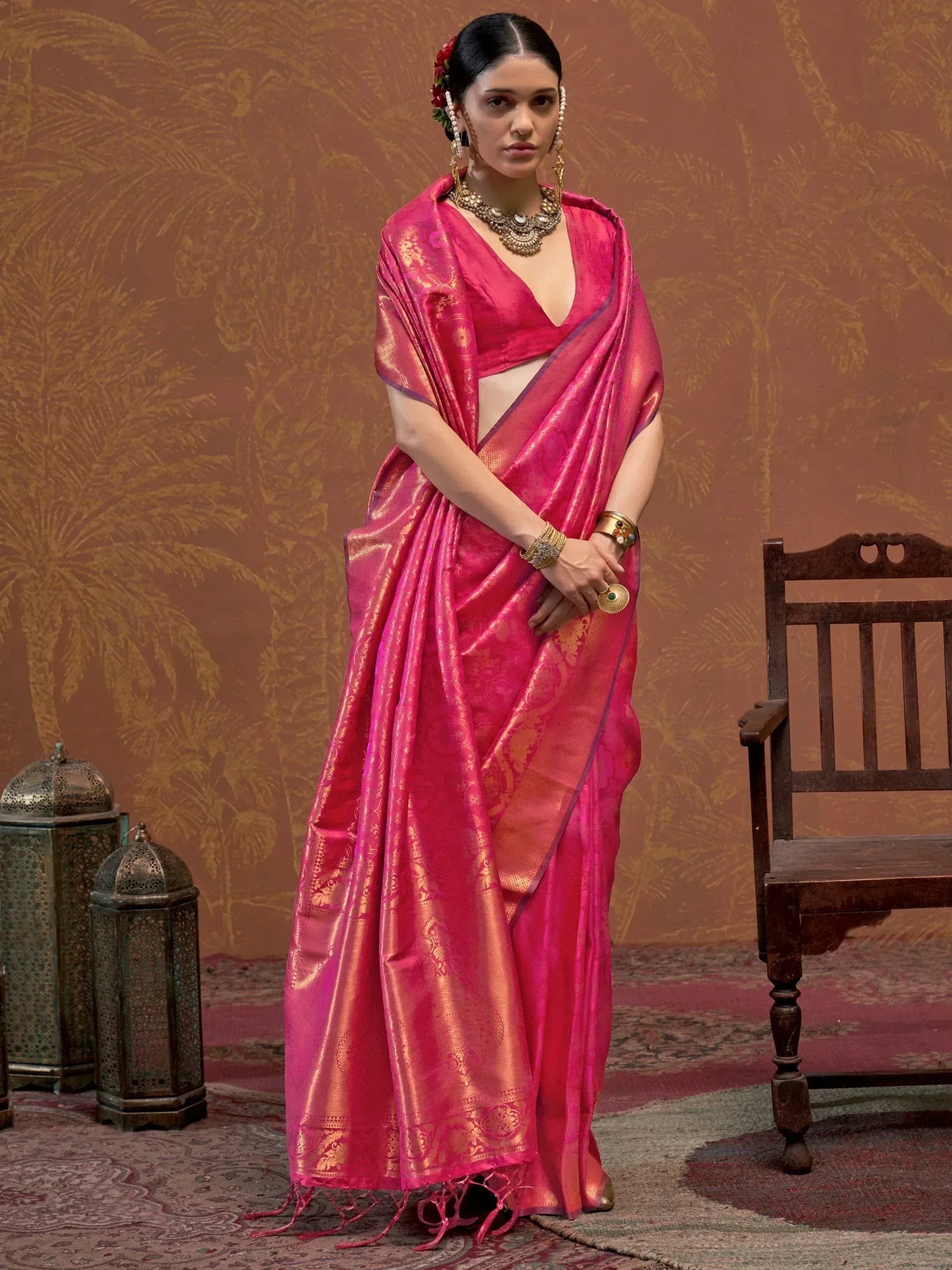 Elegant pink designer saree with gold embroidery, paired with traditional jewelry for ethnic wear.